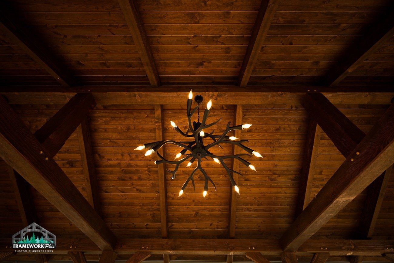A chandelier is hanging from the ceiling of a wooden building.