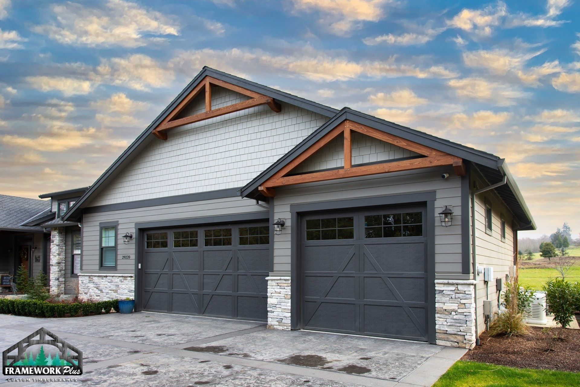 A large house with two garage doors and a wooden roof.