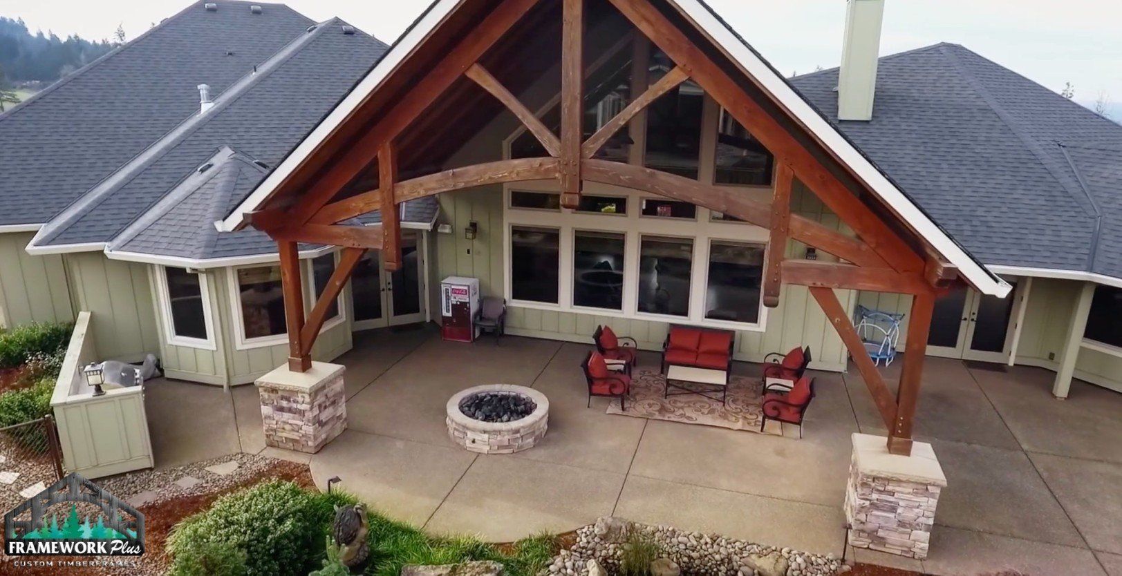 An aerial view of a large house with a fire pit in the backyard.