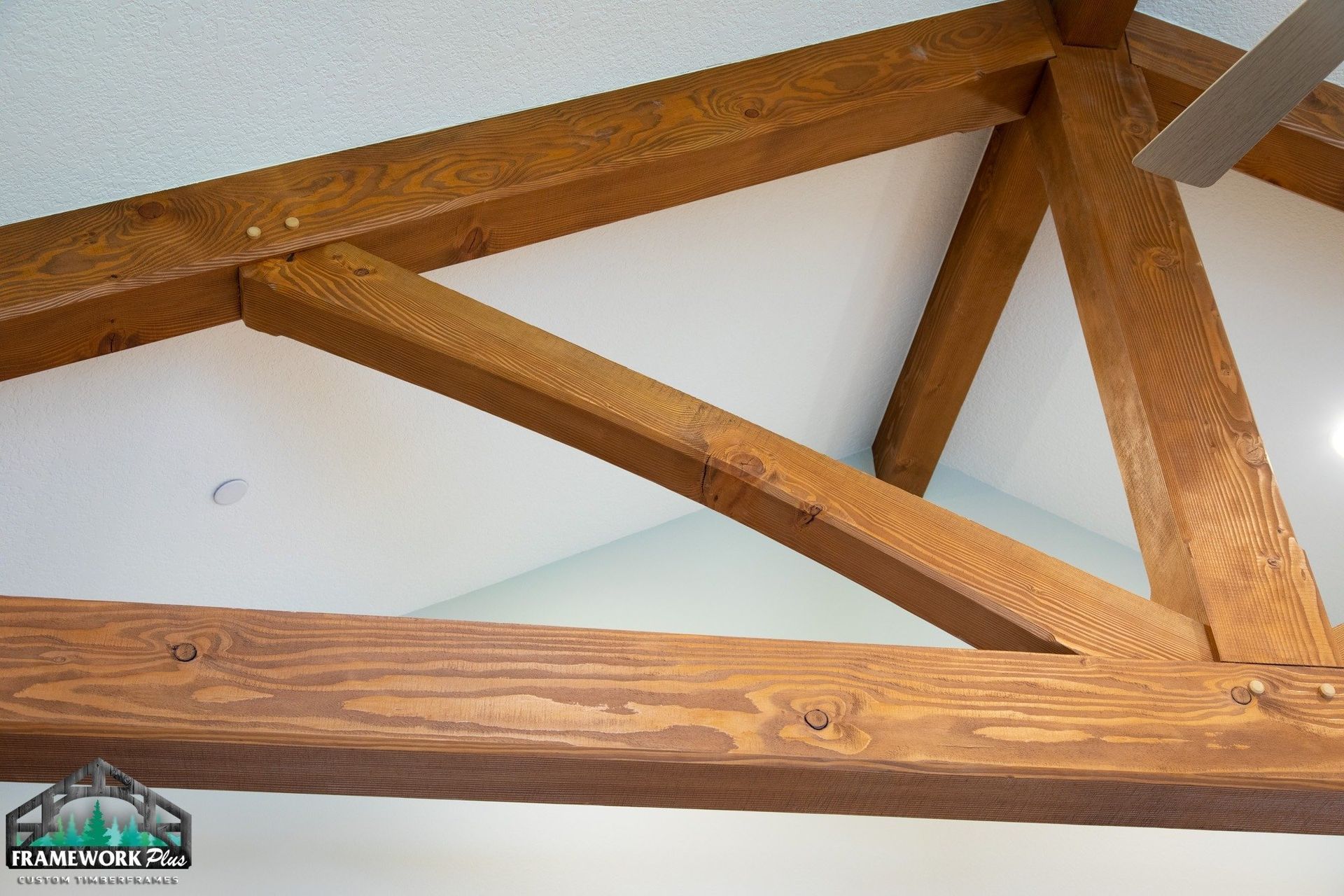 A ceiling with wooden beams and a ceiling fan