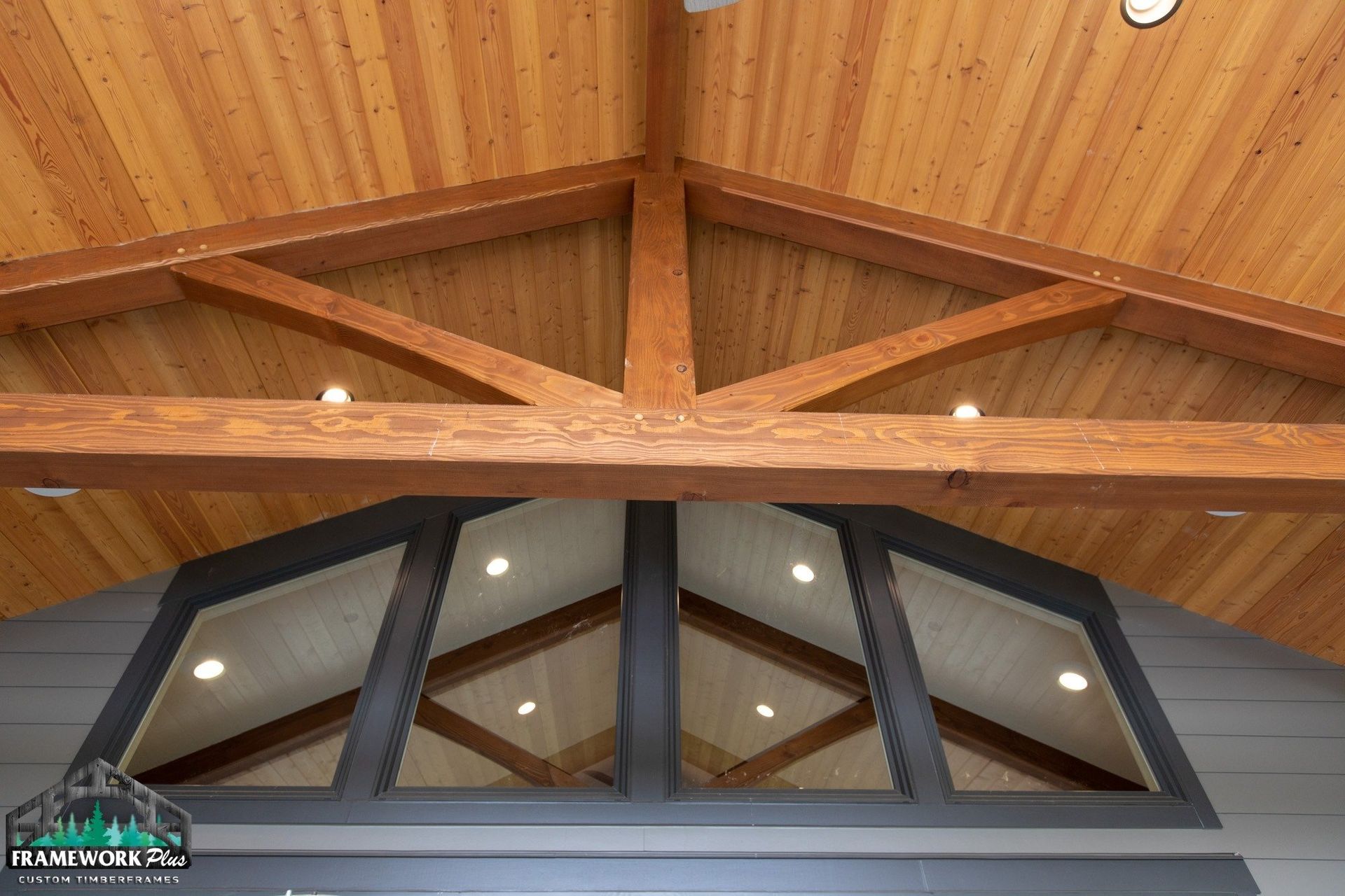 The ceiling of a building with wooden beams and a window.