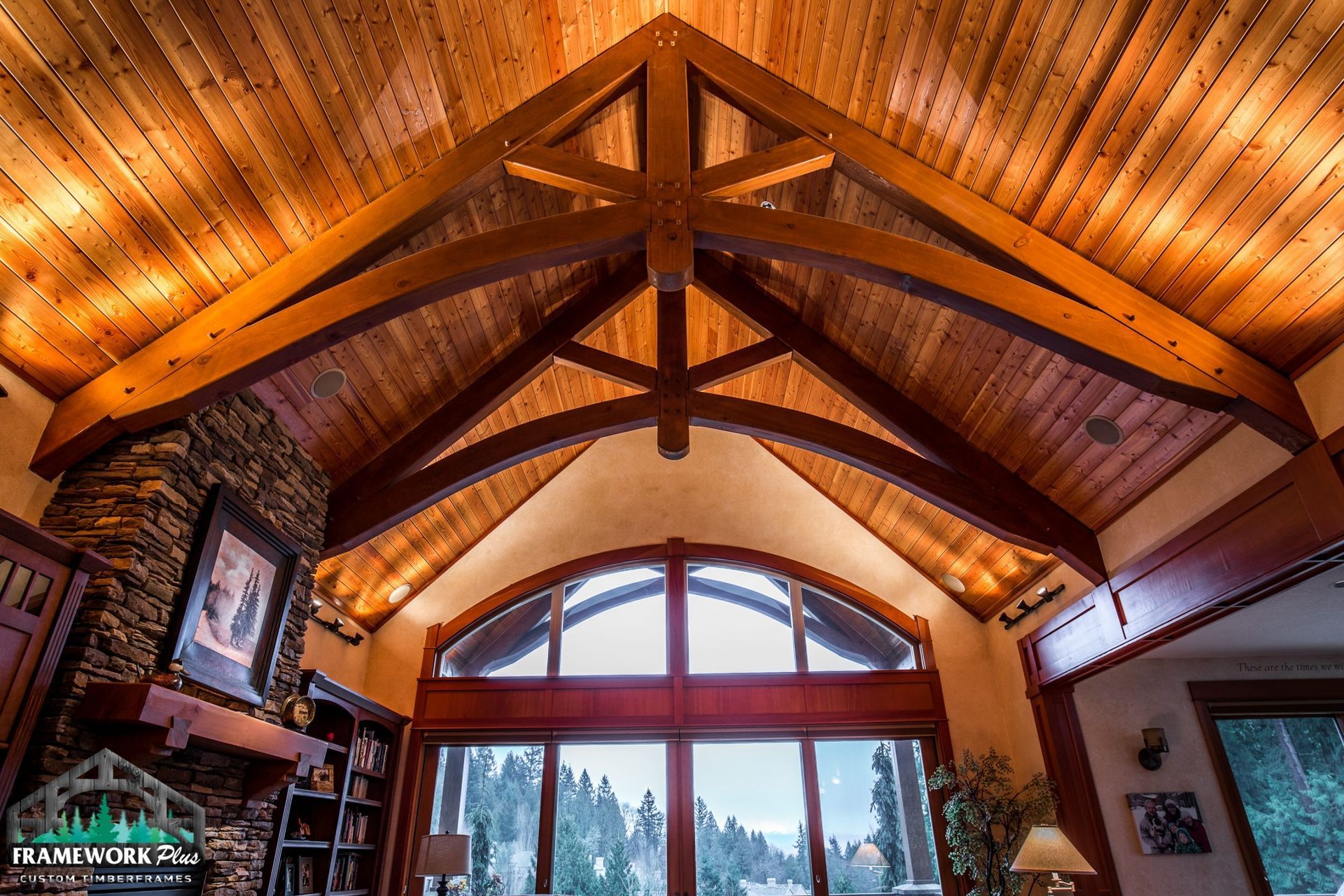 A living room with a wooden ceiling and arched windows