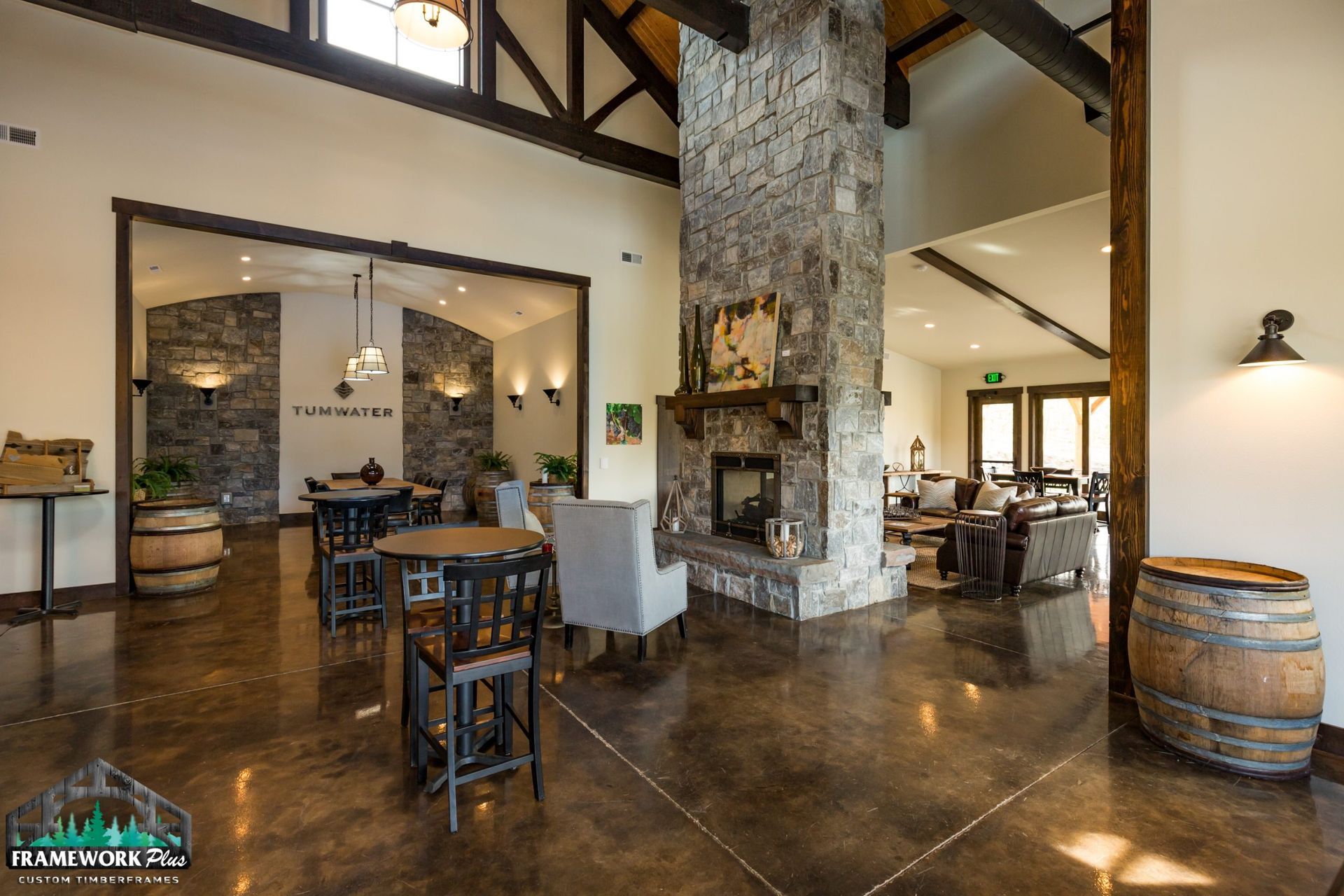 A large room with tables and chairs and a fireplace.