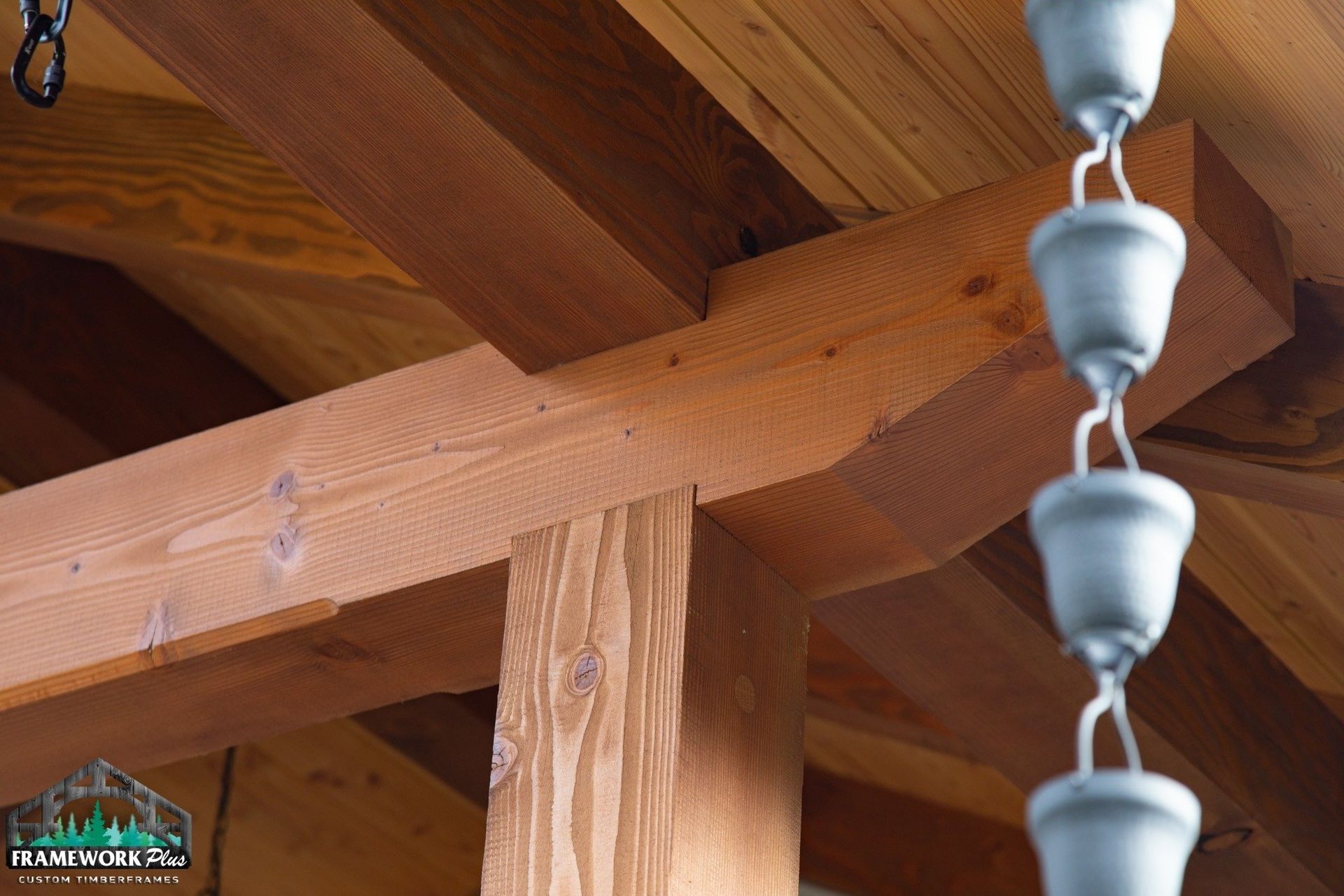 A rain chain is hanging from the ceiling of a wooden structure