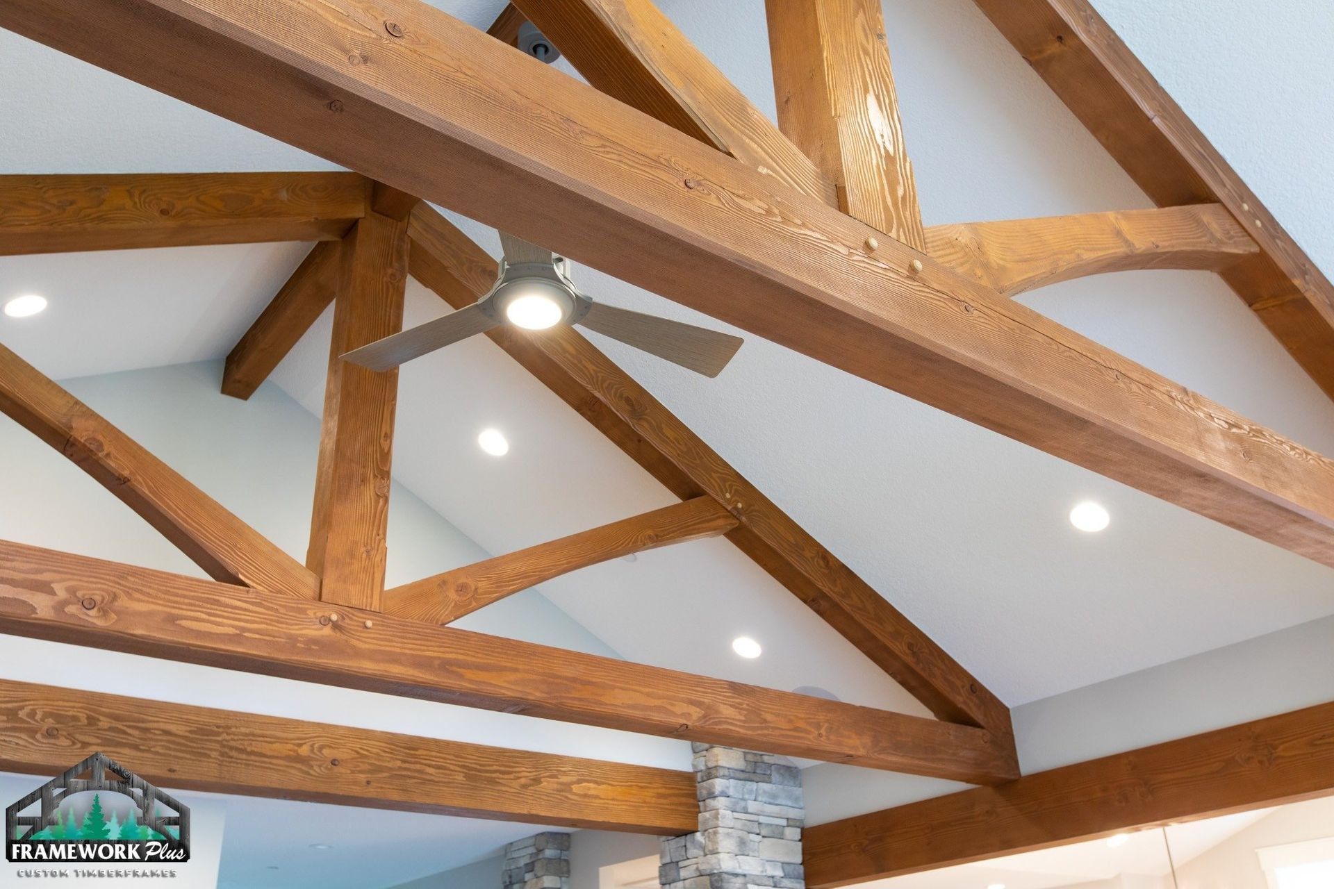 A ceiling with wooden beams and a ceiling fan.