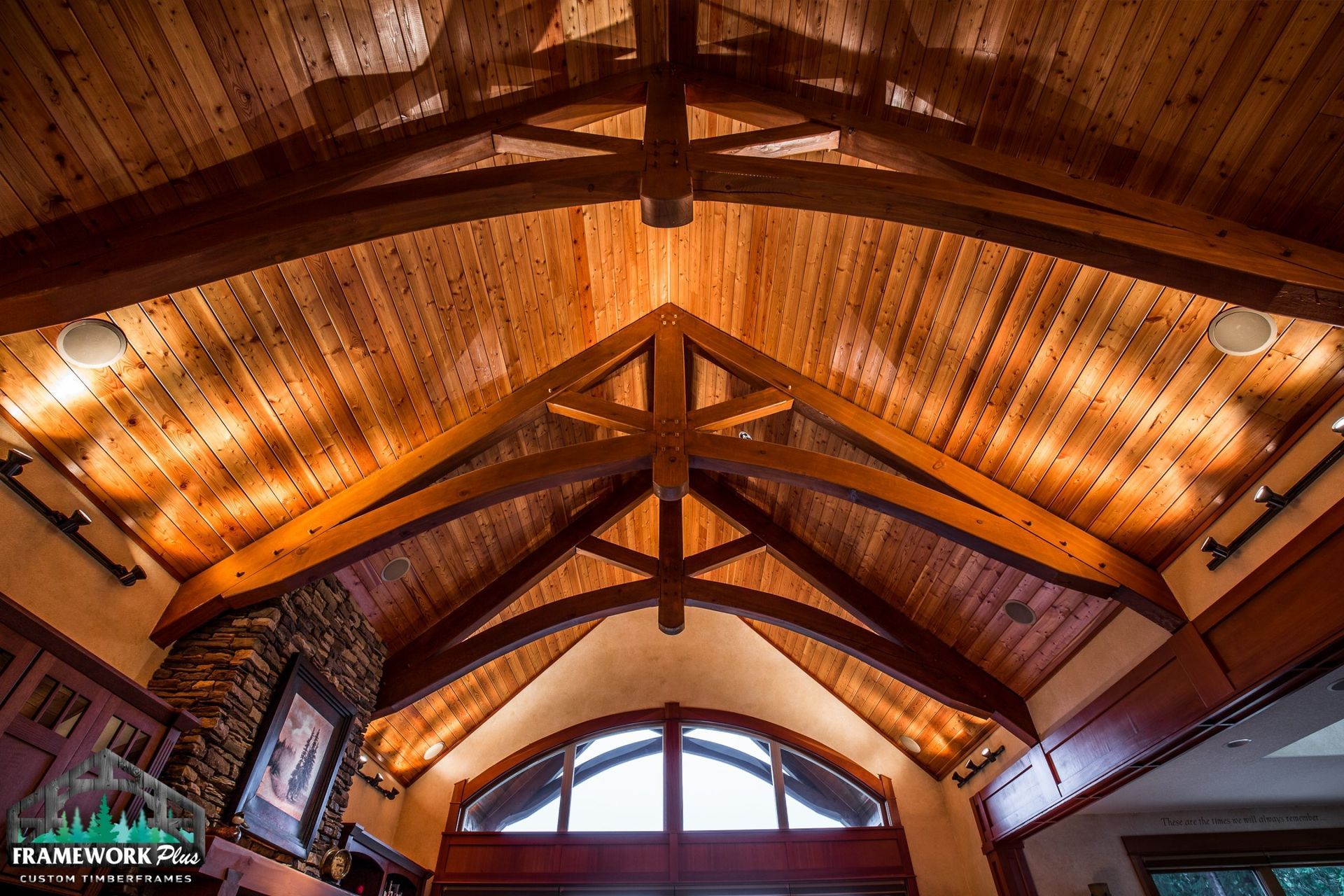 Looking up at a wooden ceiling with arched windows
