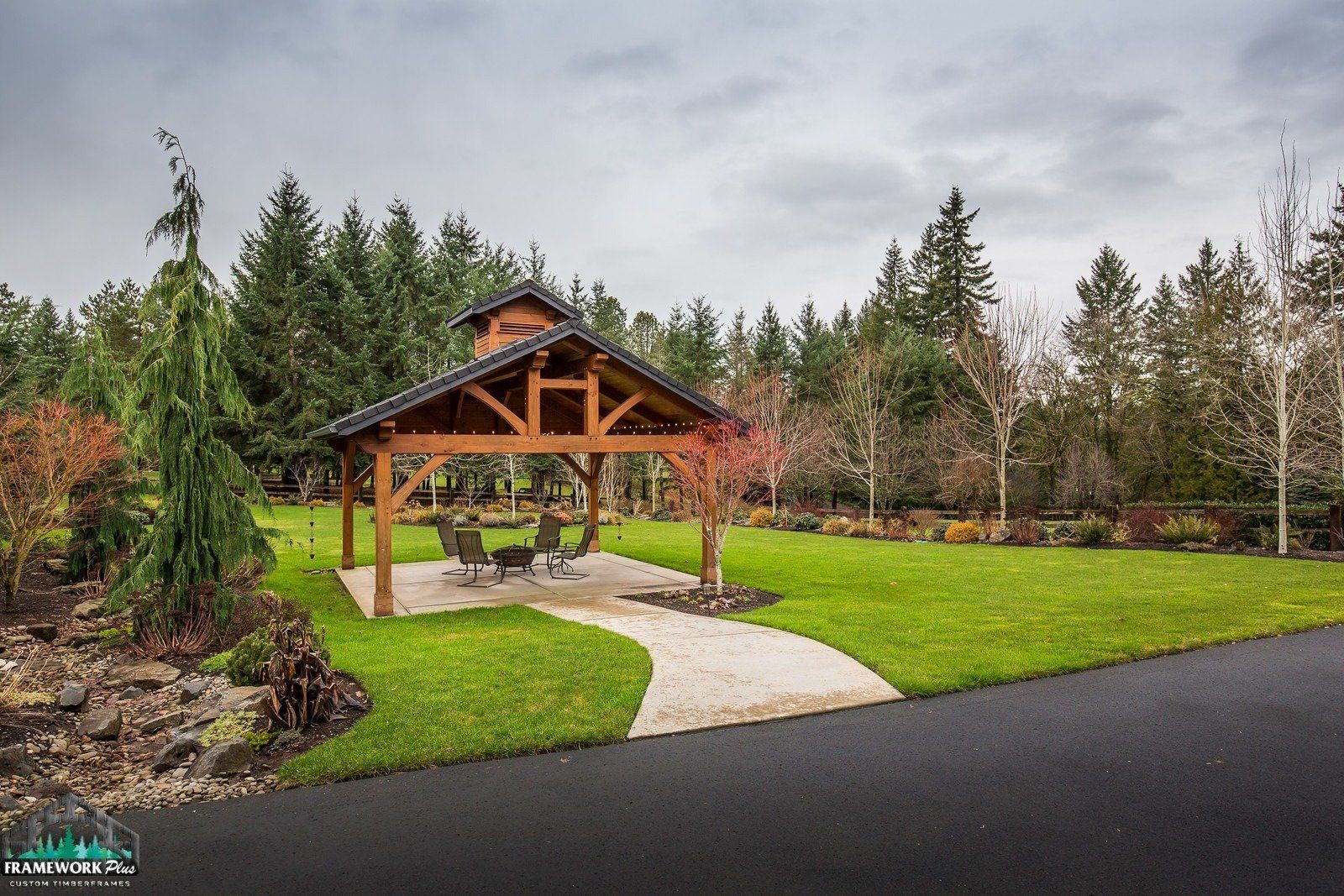 A wooden pavilion is sitting in the middle of a lush green field.