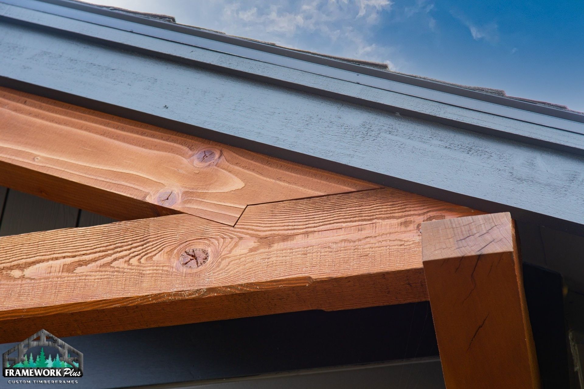 A close up of a wooden roof with a blue sky in the background.