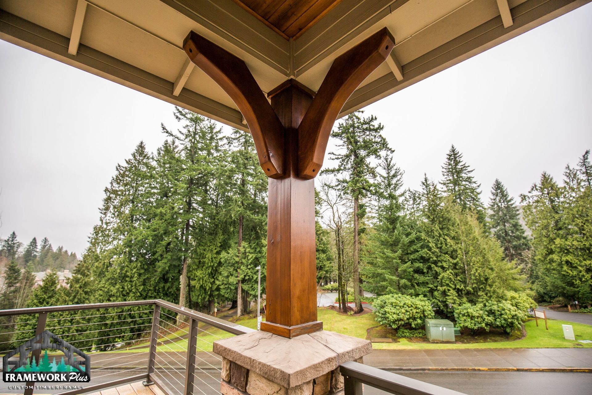 A balcony with a wooden post and trees in the background