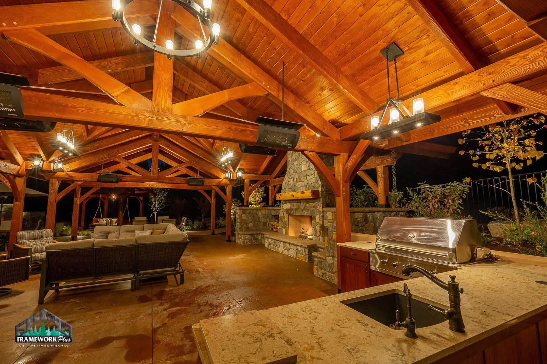 A large wooden pavilion with a fireplace and a sink.