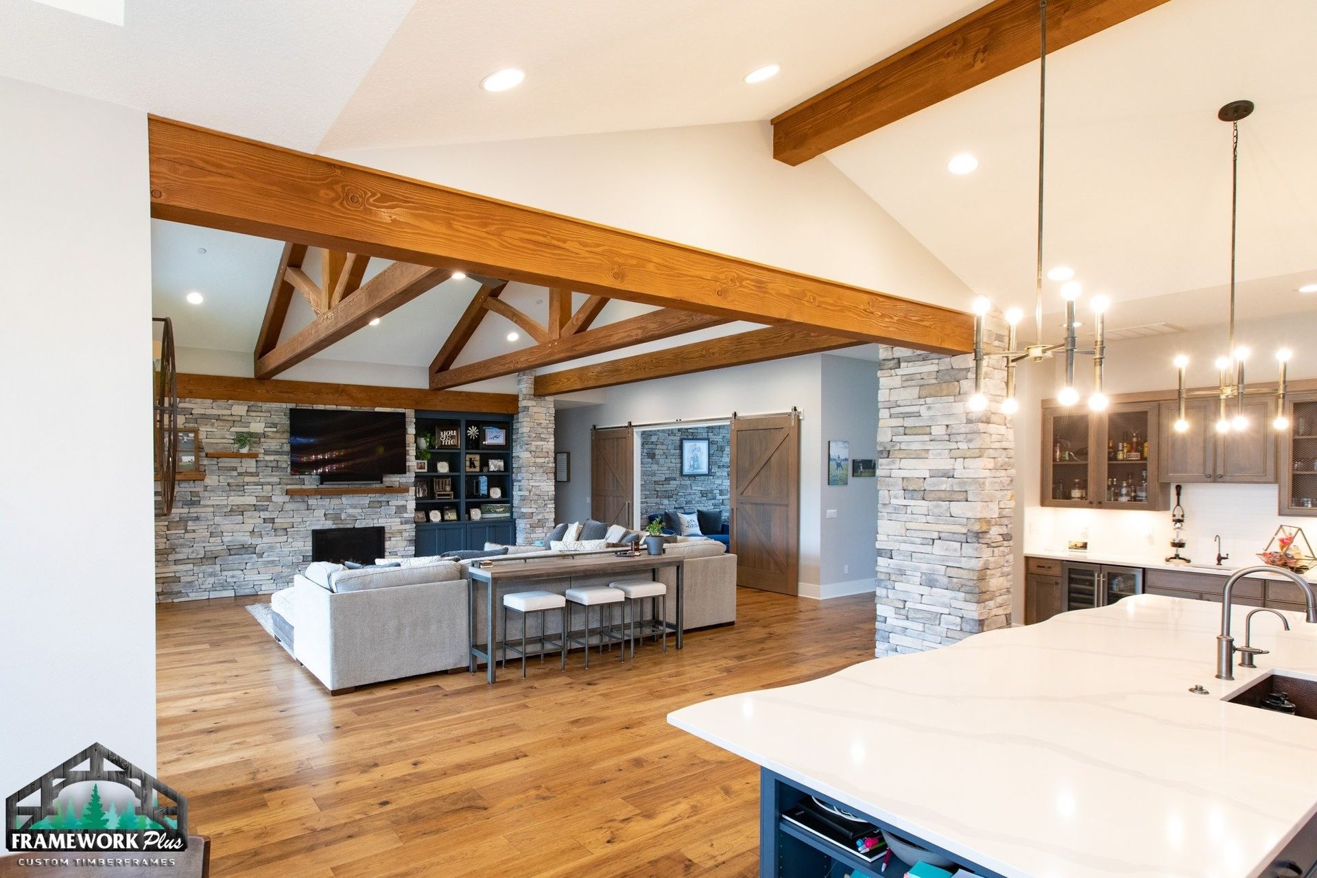 A living room and kitchen in a house with wooden beams.