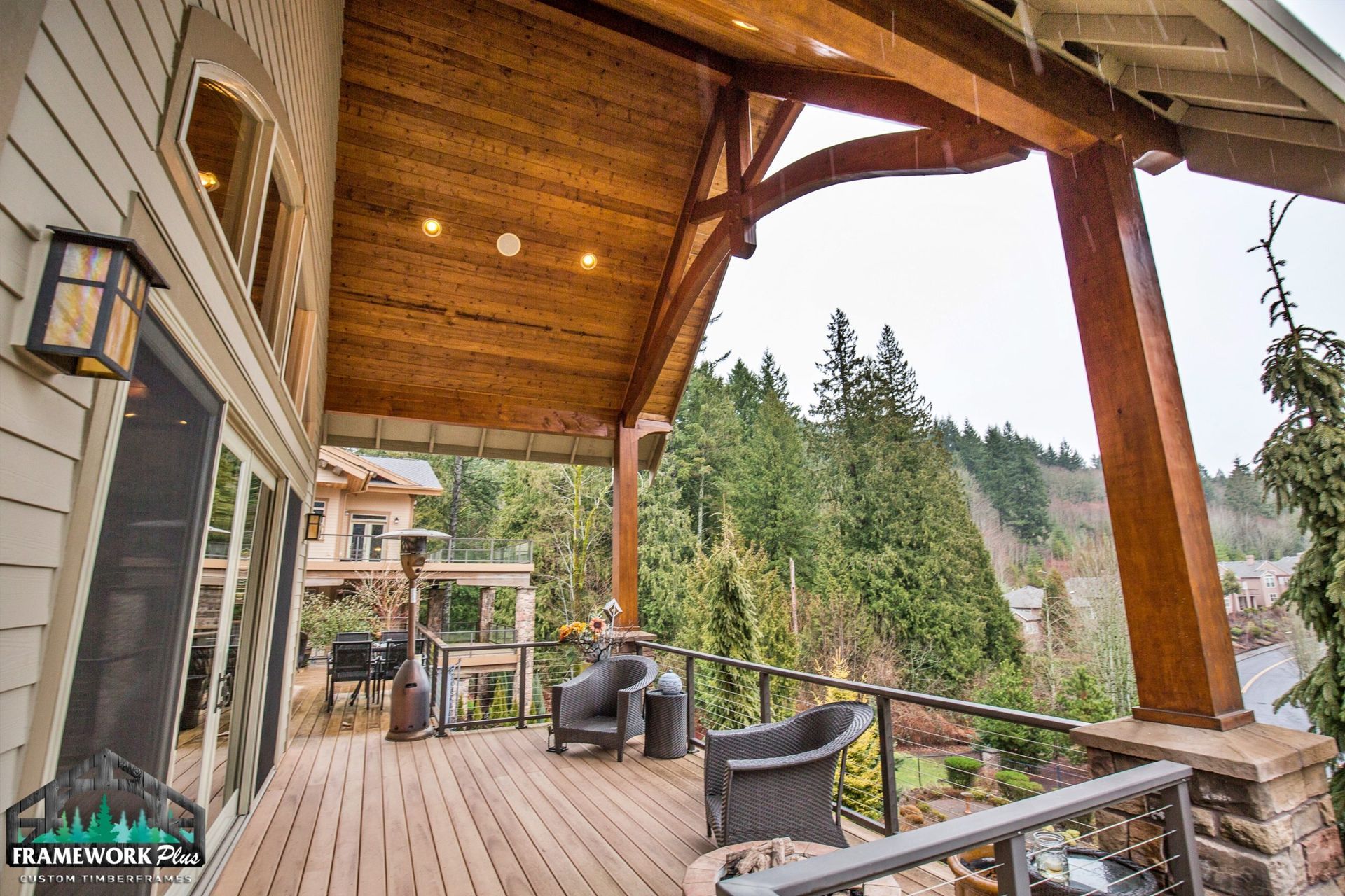 A large wooden deck with a view of a forest.