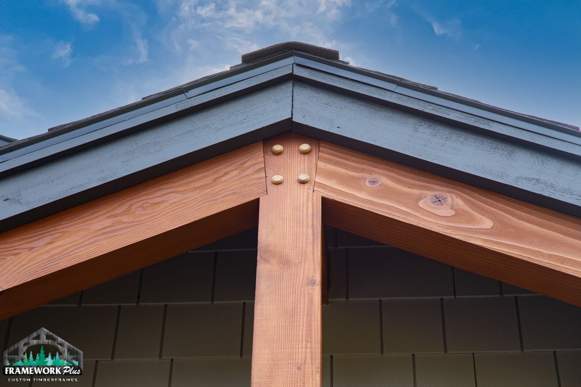 A close up of a wooden roof with a blue sky in the background.