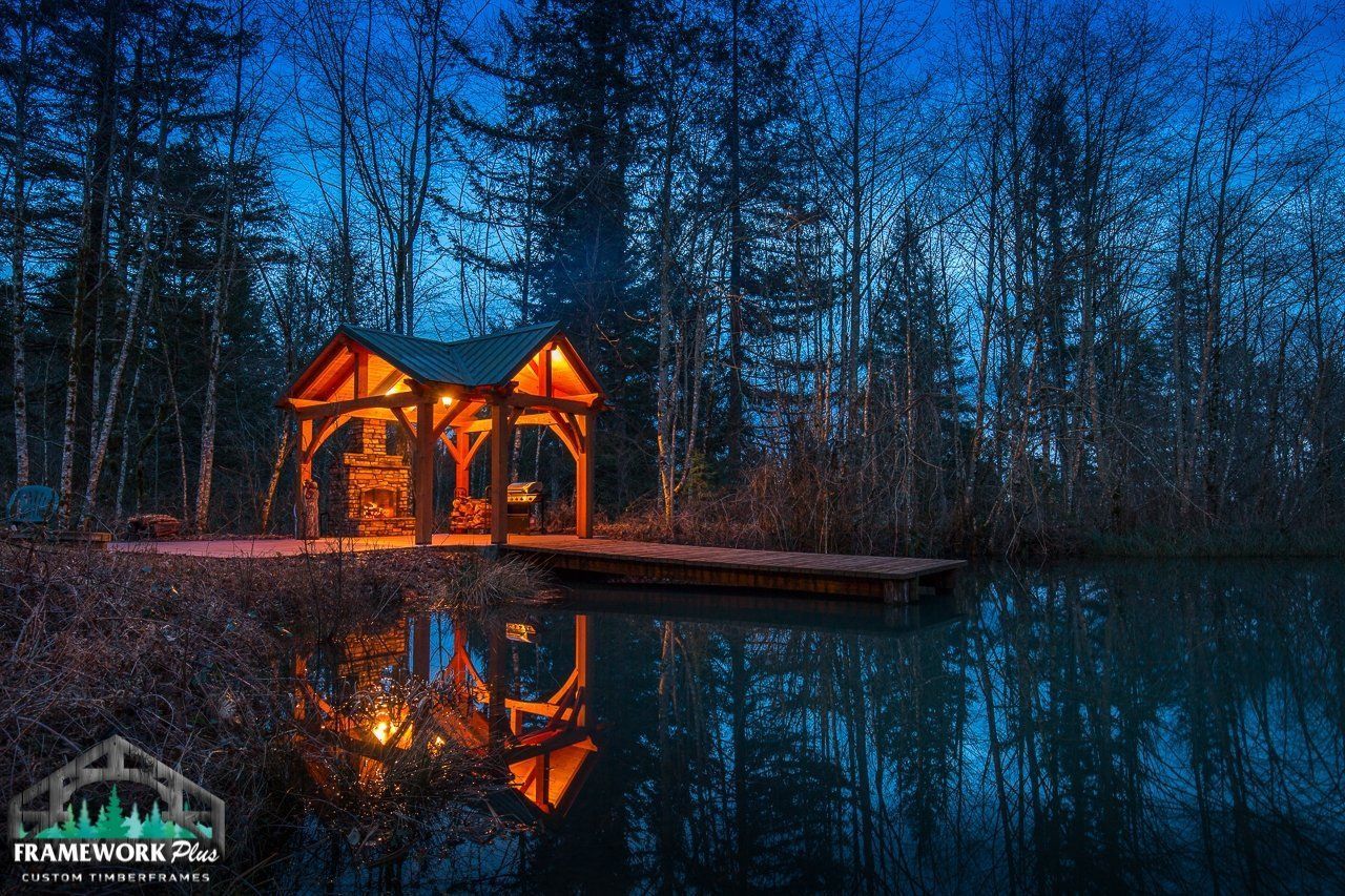 A gazebo is lit up in the middle of a lake