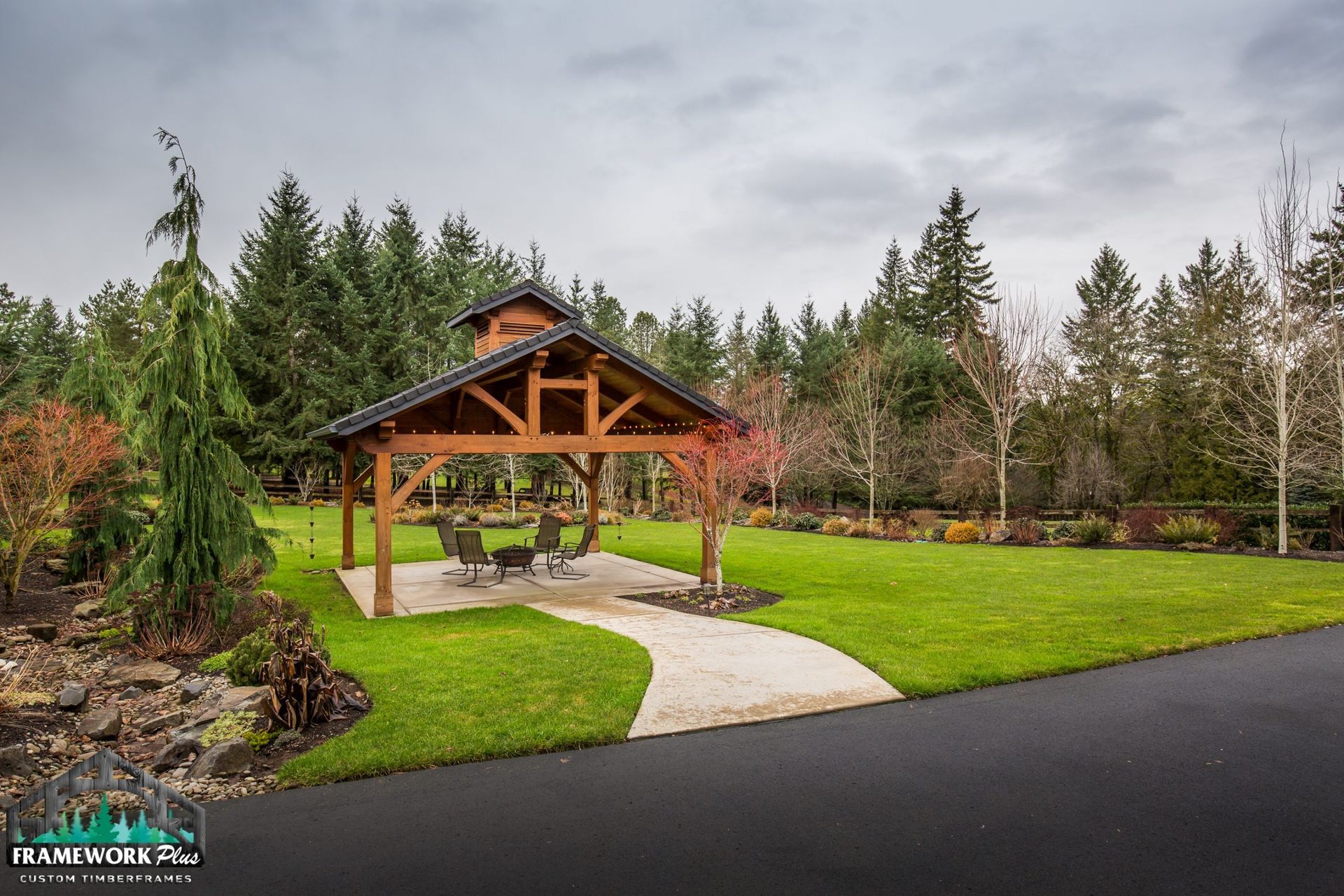 A wooden pavilion is sitting in the middle of a lush green field.