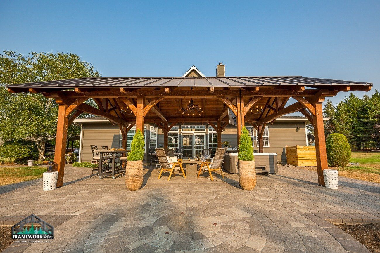 A large wooden pavilion is sitting in front of a house.