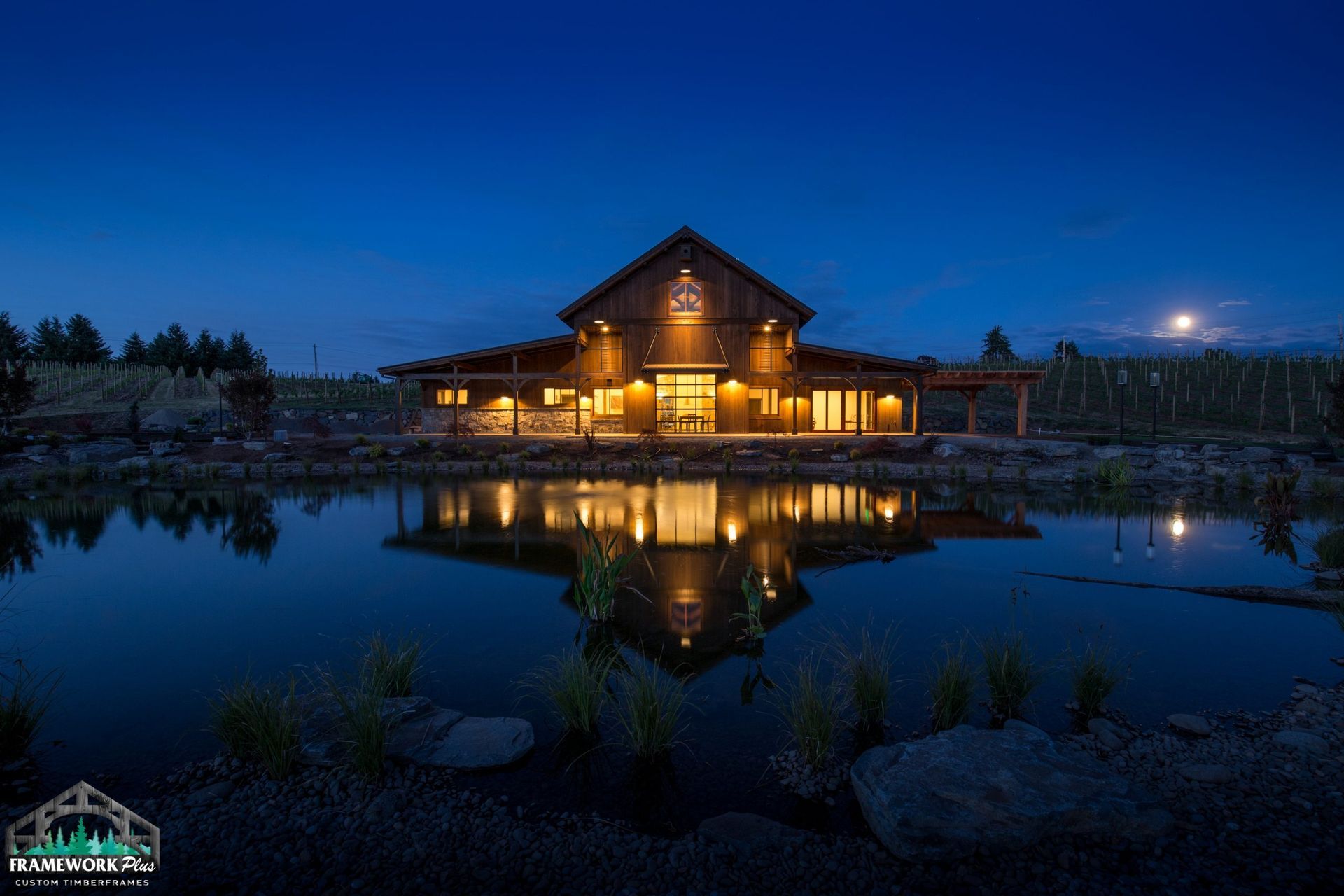 A large house is sitting next to a body of water at night.