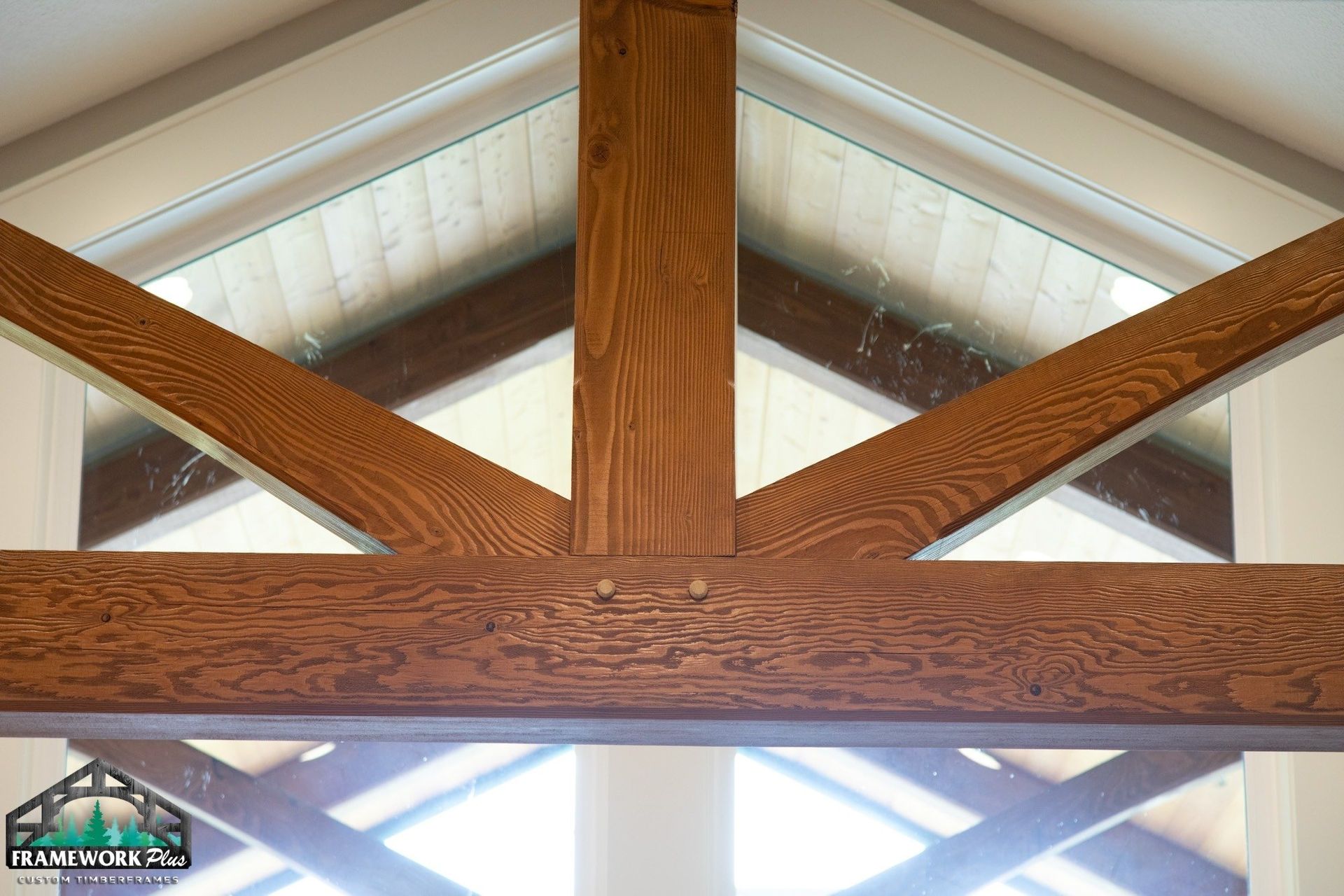 The ceiling of a room with wooden beams and a window.