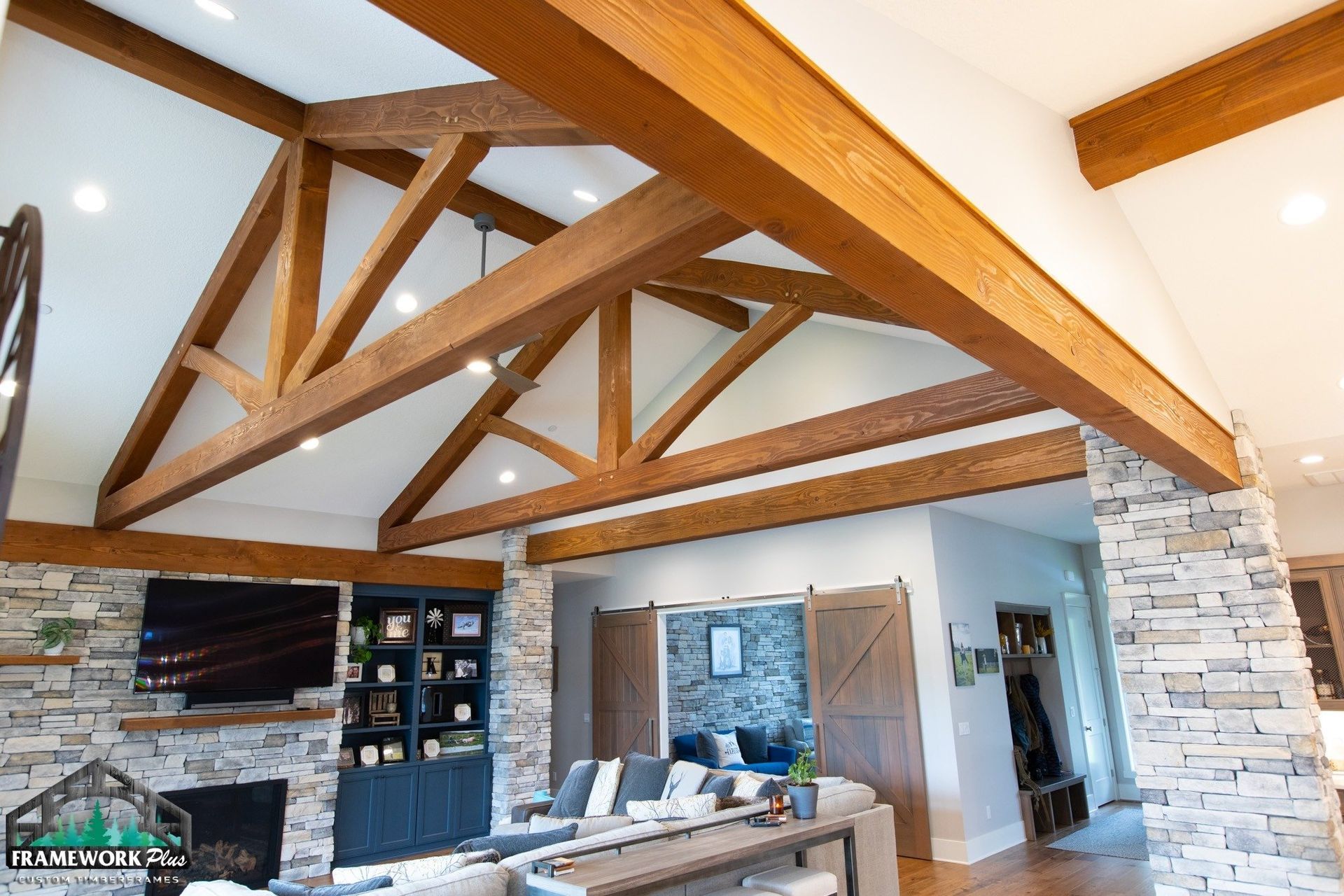 A living room with a vaulted ceiling and wooden beams.