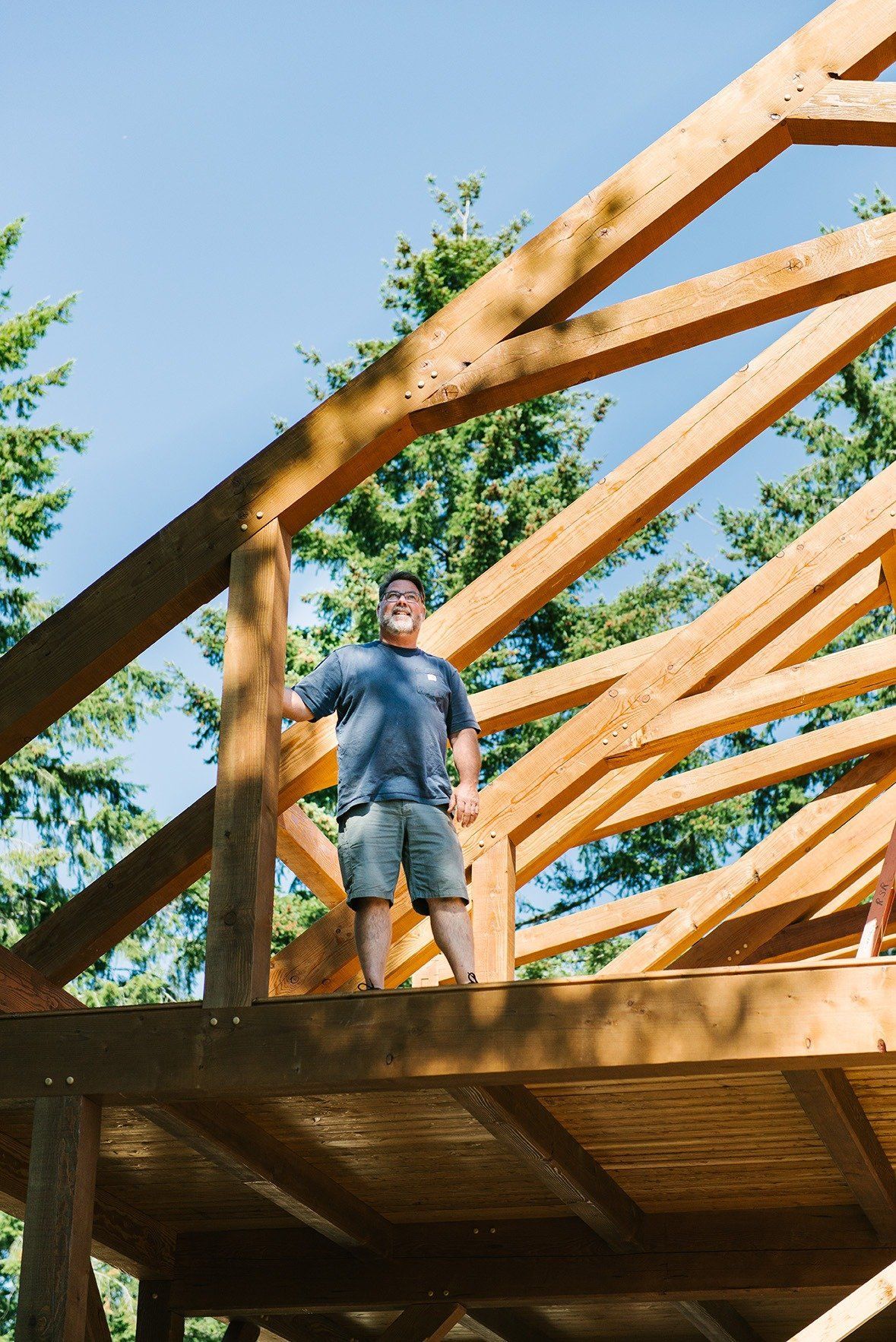 A man is standing on top of a wooden structure.