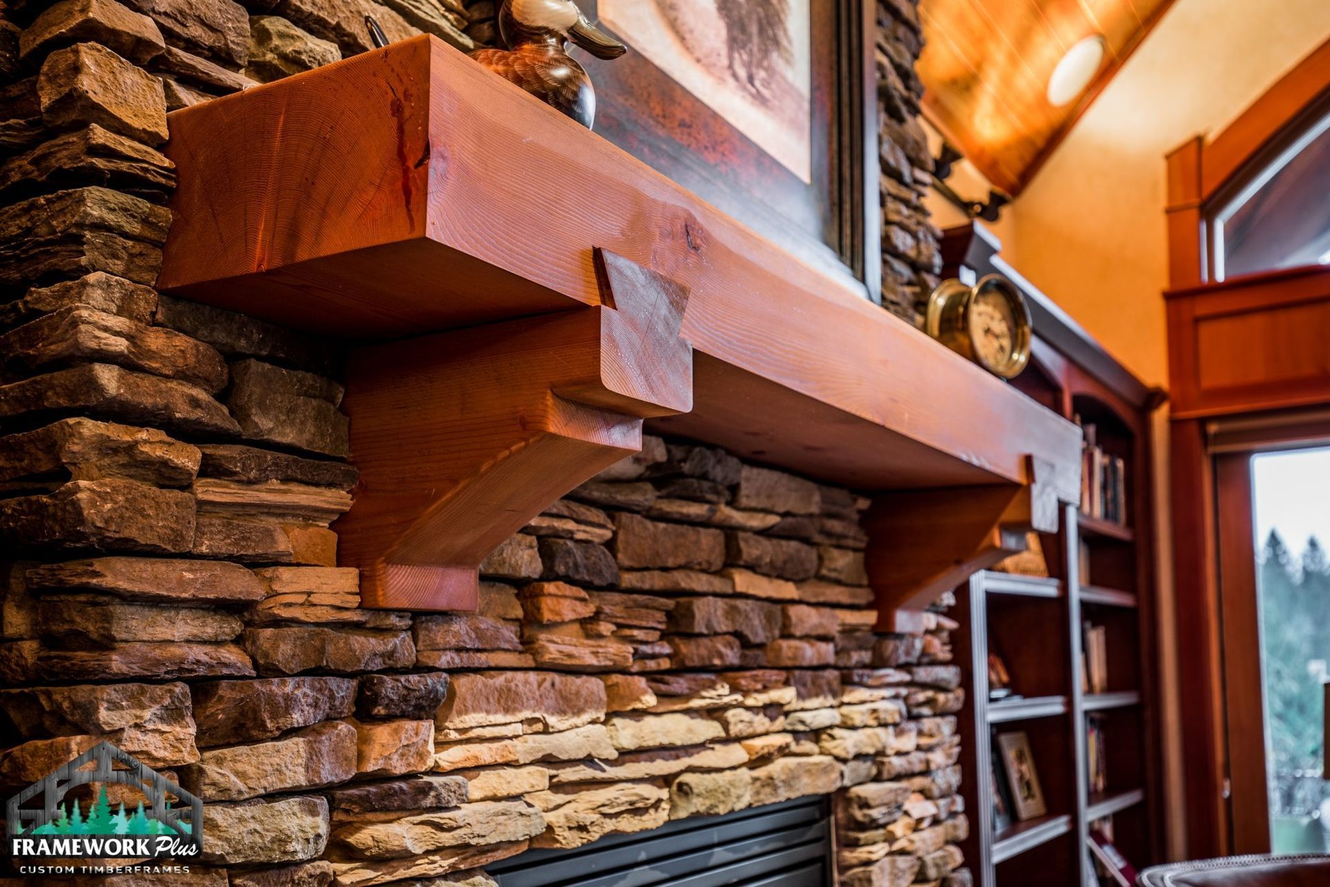 A fireplace with a wooden mantle and a stone wall