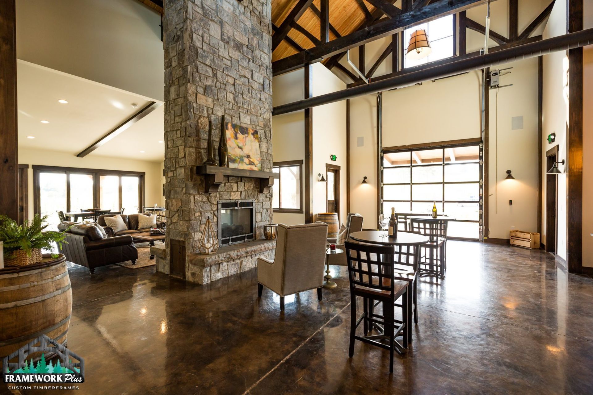 A living room with a stone fireplace , tables and chairs.