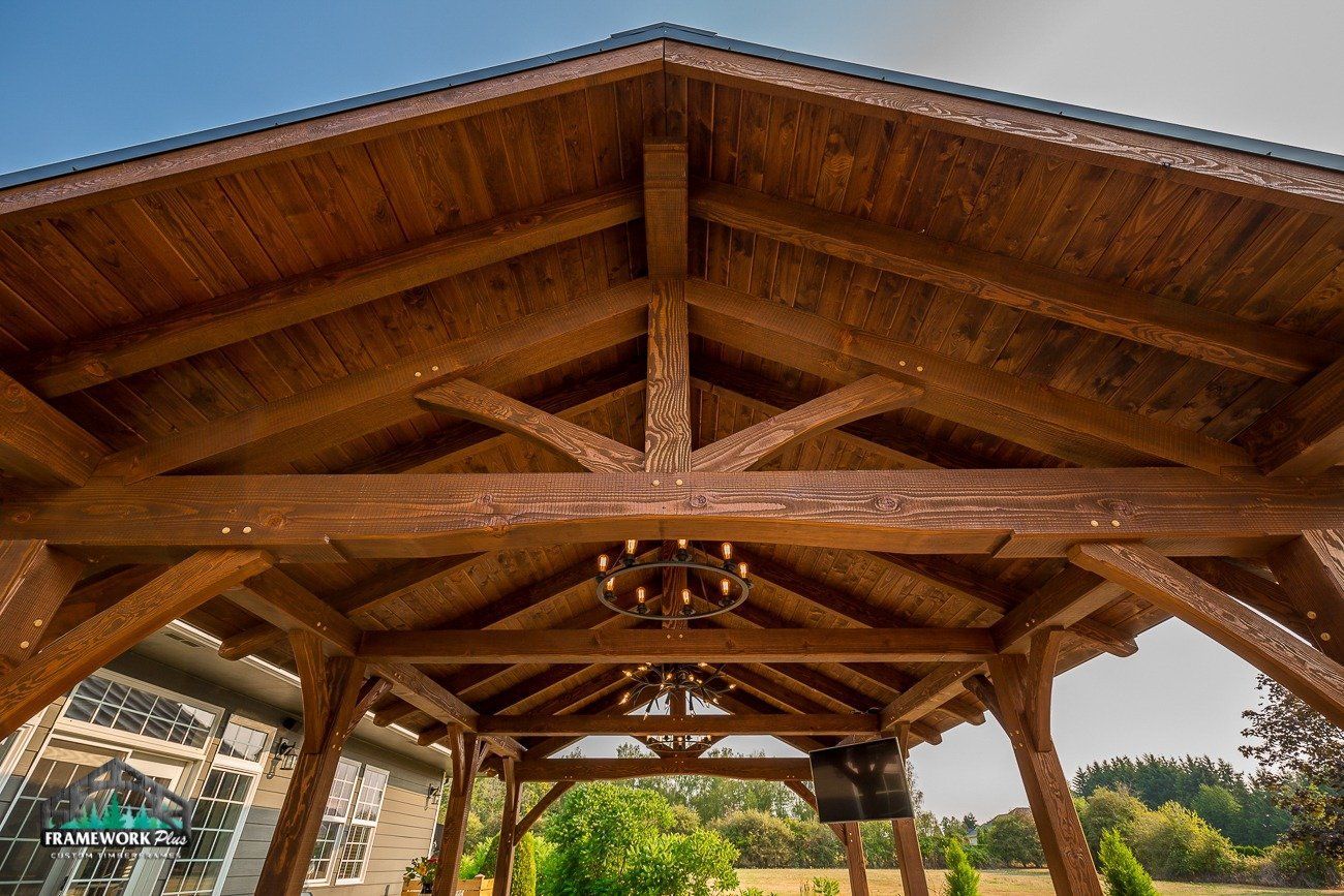 A wooden gazebo with a chandelier hanging from the ceiling.