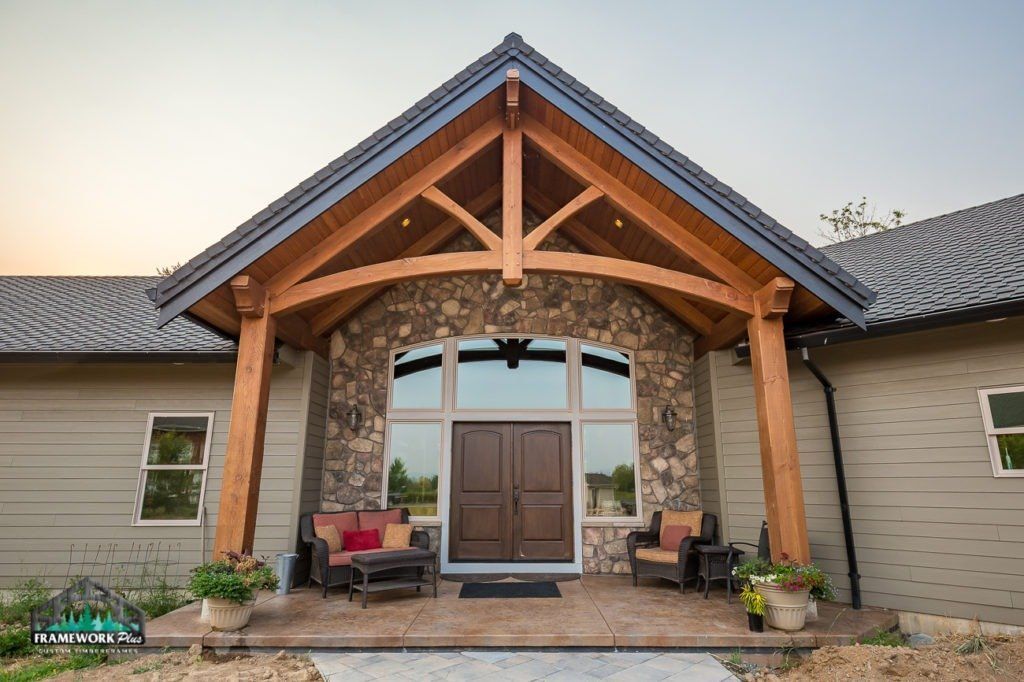 A large house with a wooden porch and a stone wall