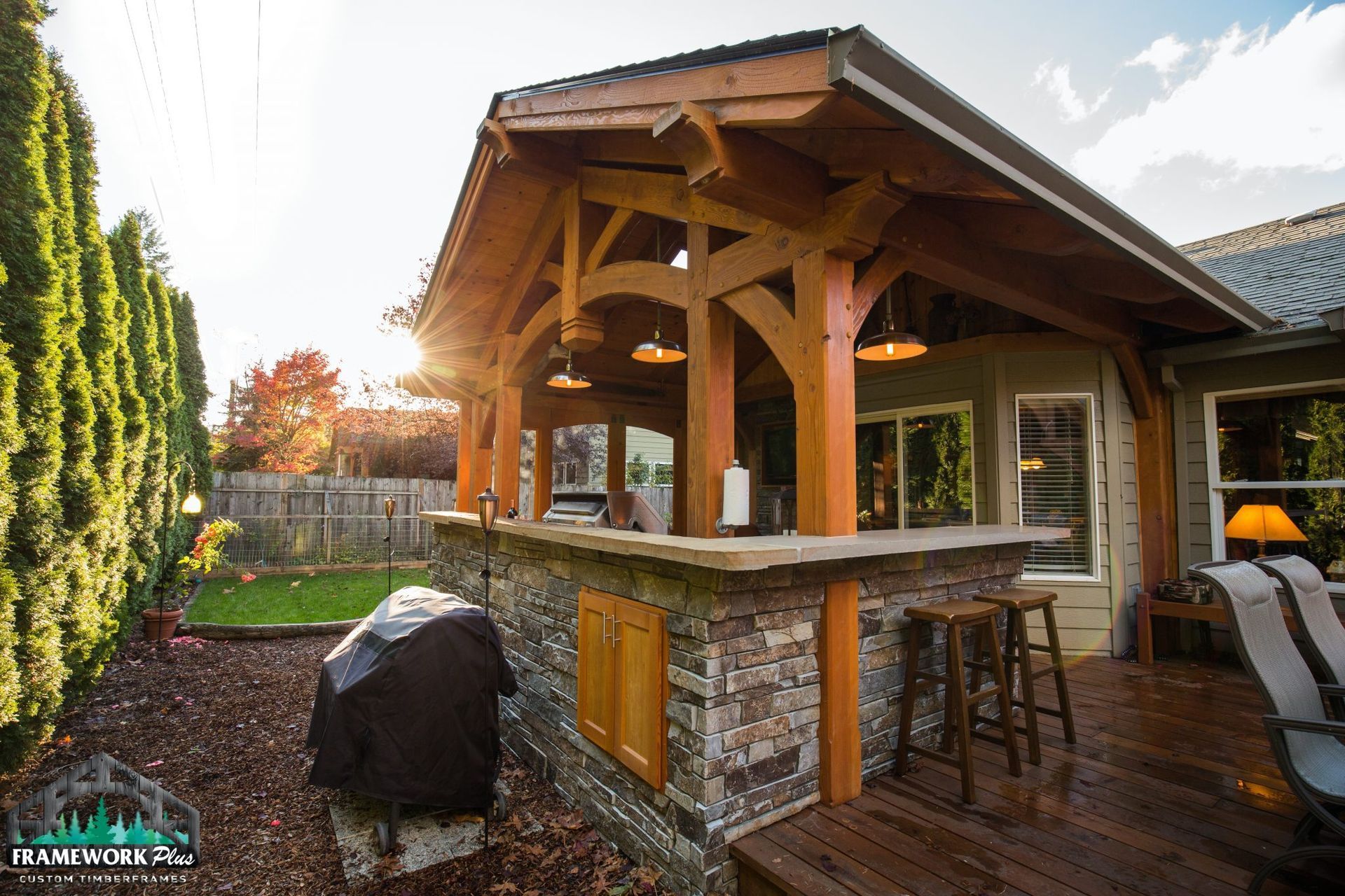 A house with a wooden roof and a stone bar in the backyard.
