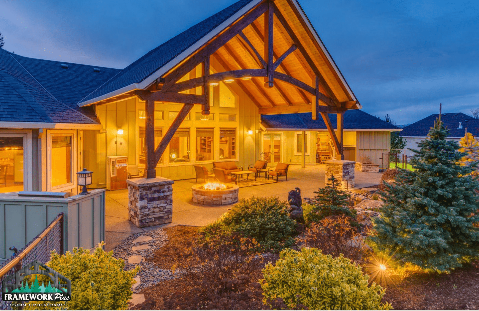 A large house with a fire pit in the backyard at night.