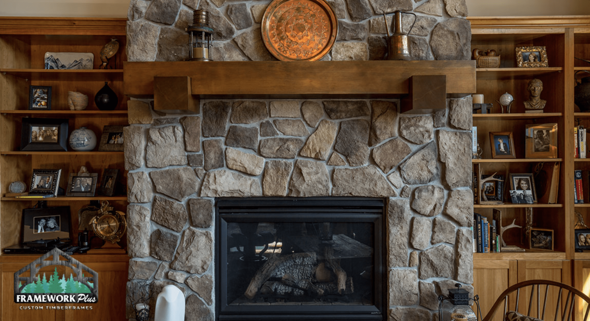 There is a fireplace in the middle of the room with a stone wall.