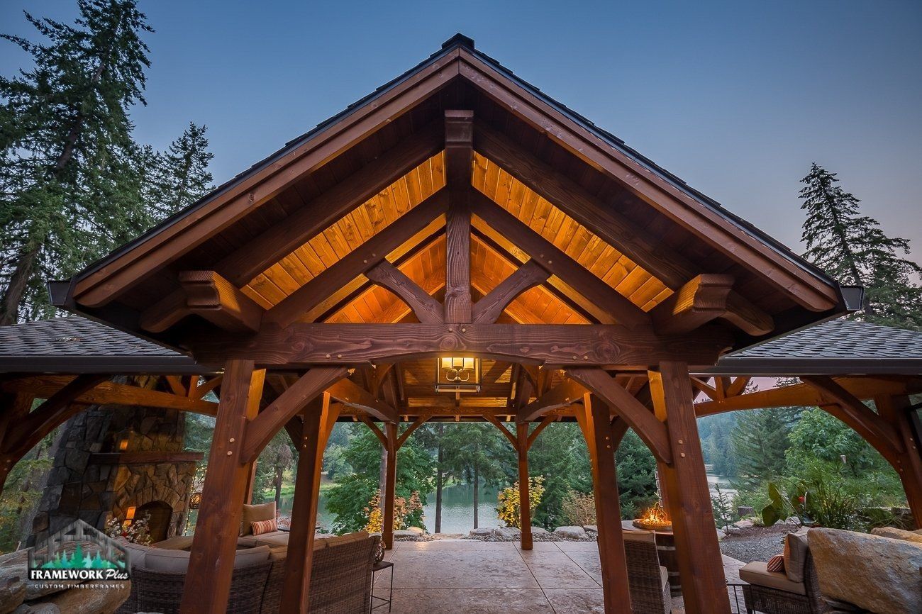 A wooden gazebo with a roof that is lit up at night