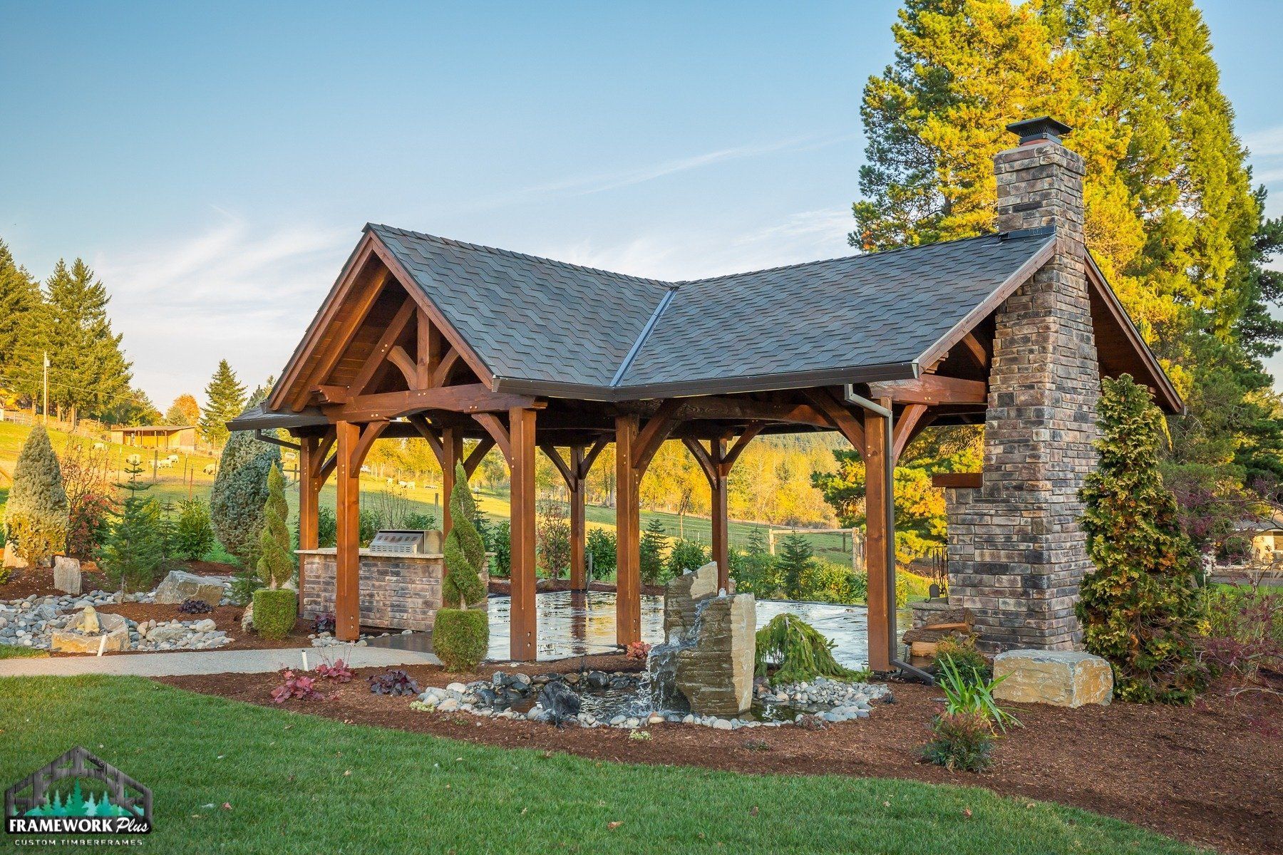 A wooden pavilion with a stone chimney and a slate roof