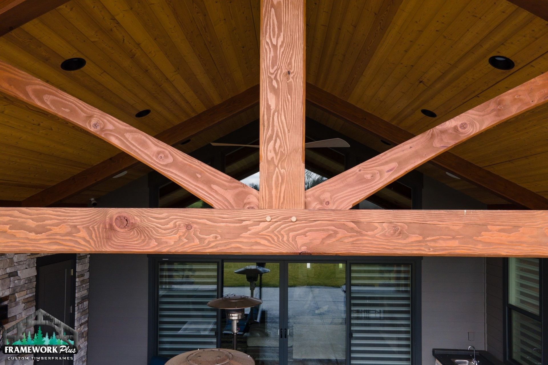 The ceiling of a house with wooden beams and a sliding glass door.
