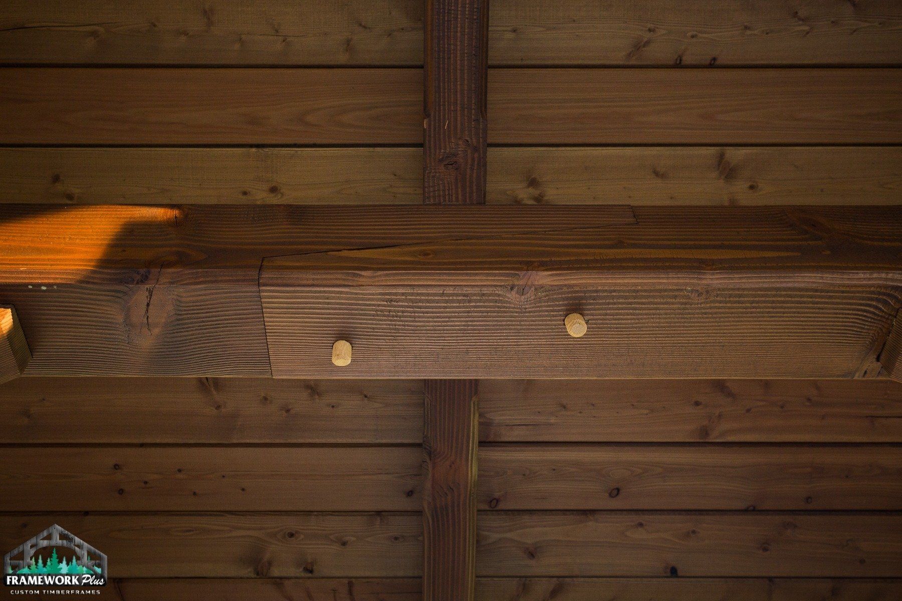 A wooden shelf is hanging from the ceiling of a wooden building.