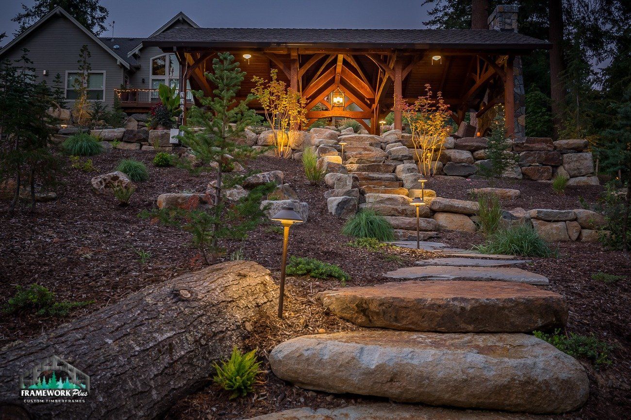 A stone walkway leading to a house with stairs leading up to it.