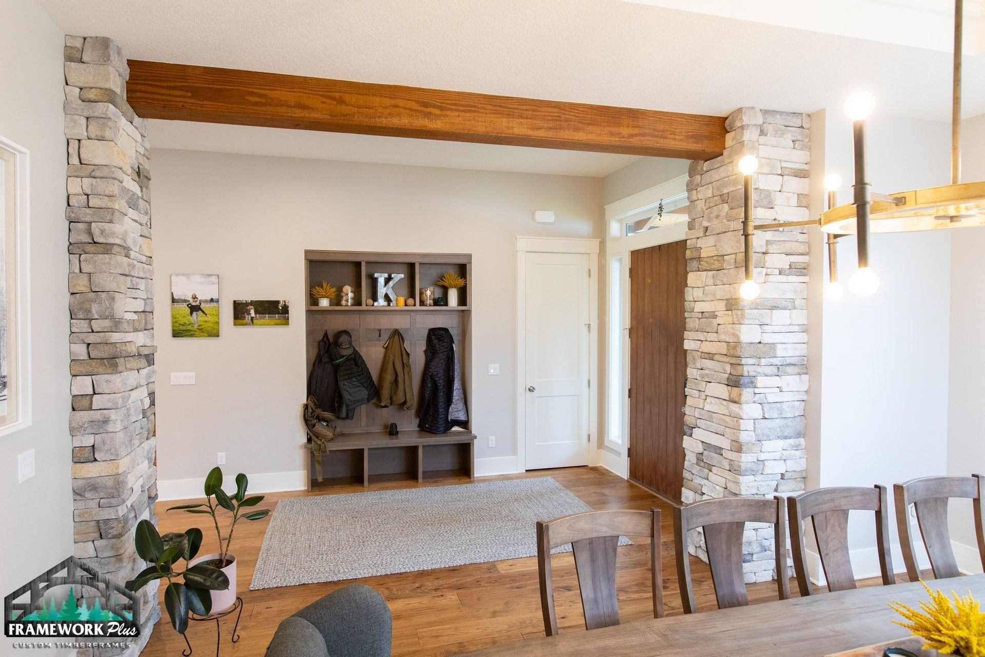 A living room with a dining table , chairs , and a brick wall.