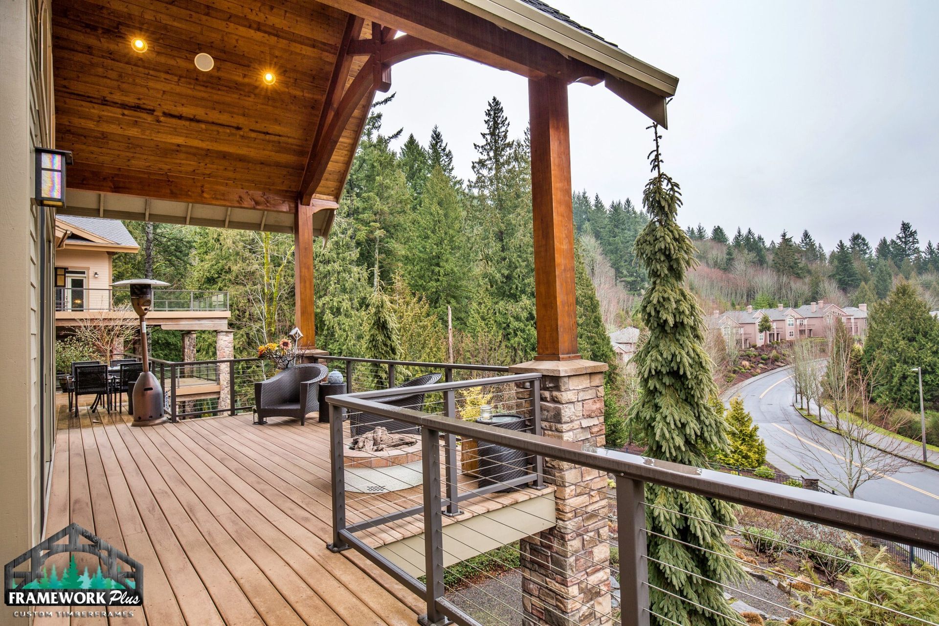 A large deck with a view of a forest and a road.