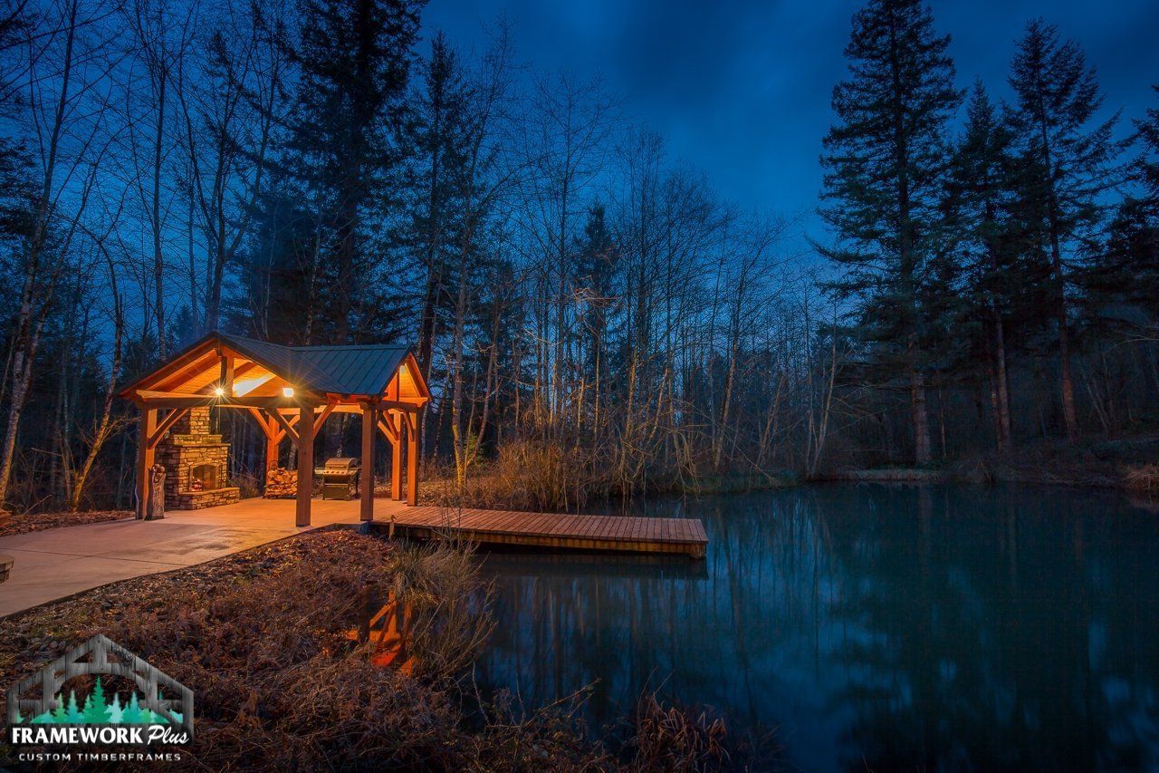 A dock in the middle of a forest next to a lake at night.