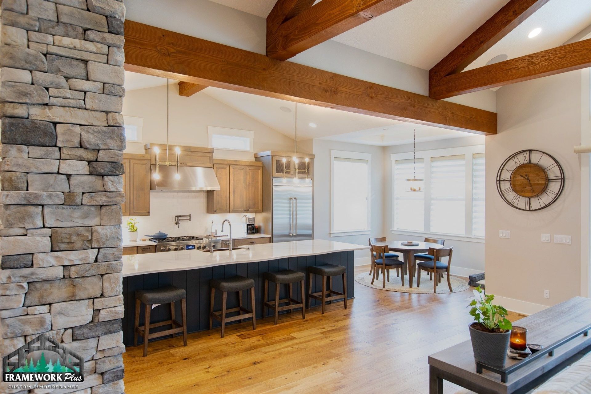 A kitchen and dining room are connected by a stone wall.