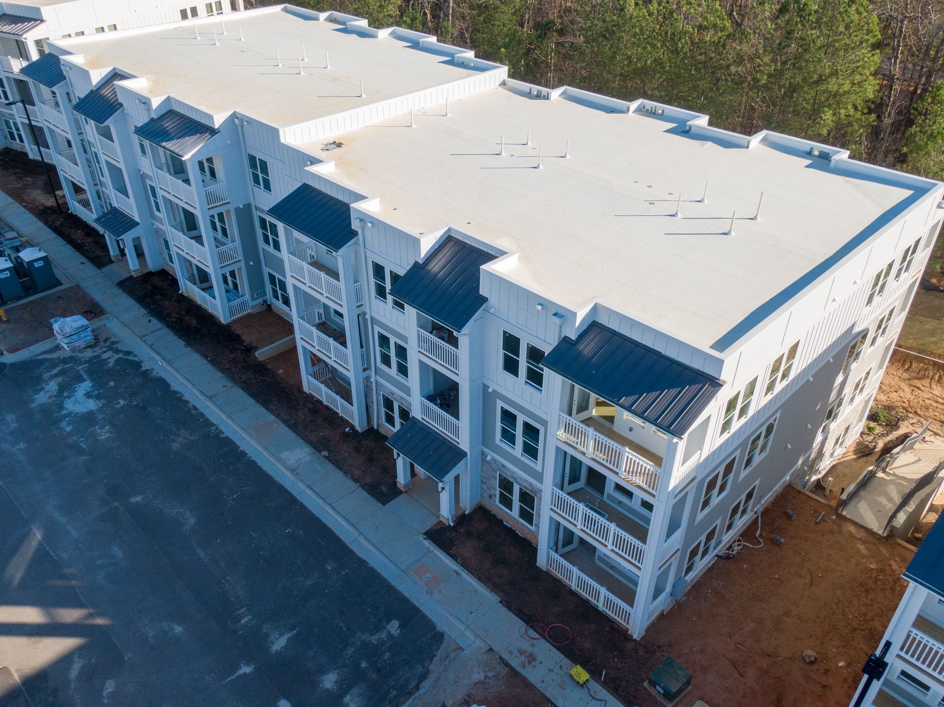 Apartment building under construction with a TPO roof.