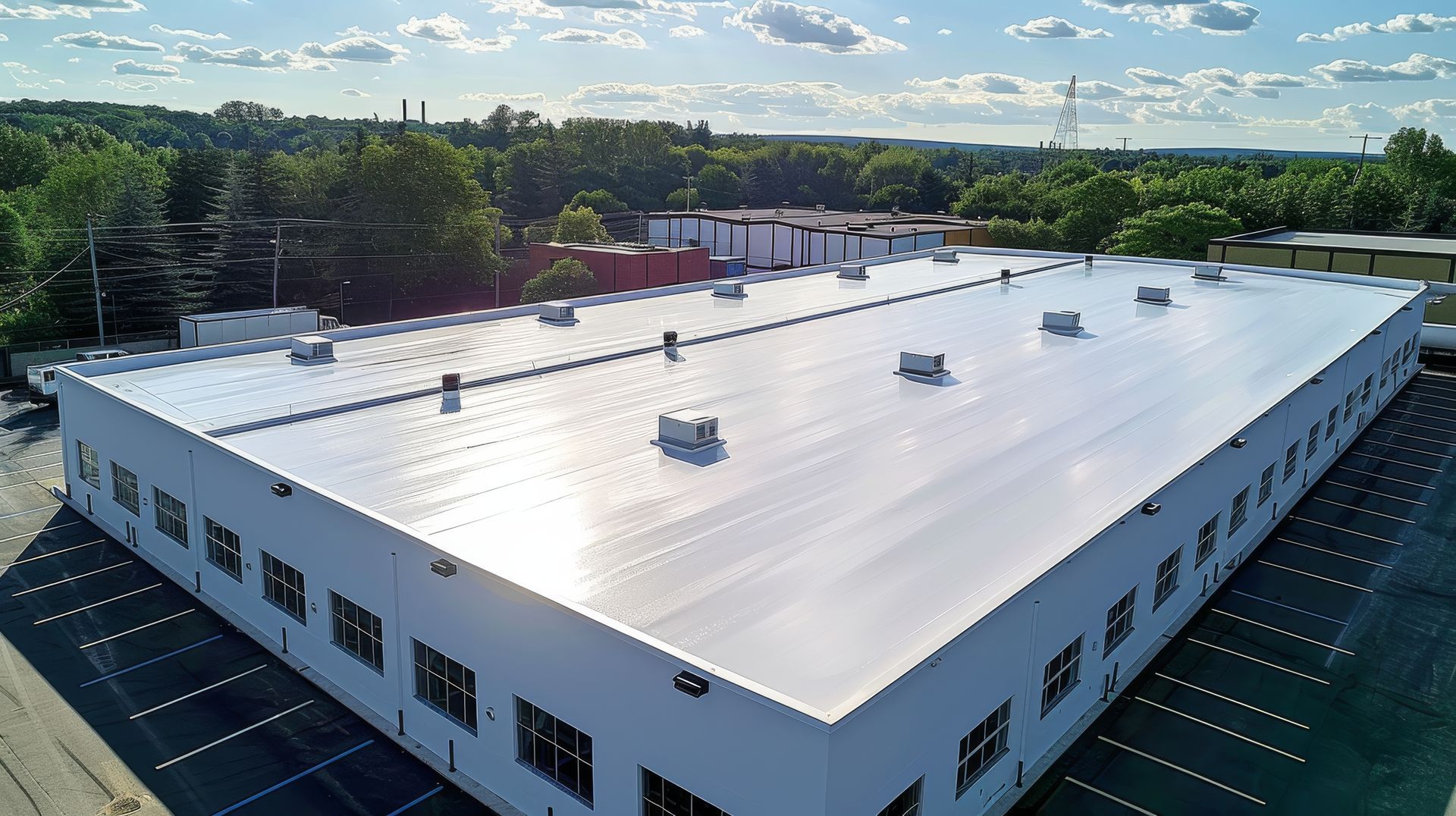 Commercial roofing contractor installing durable white TPO membrane on a large industrial building.