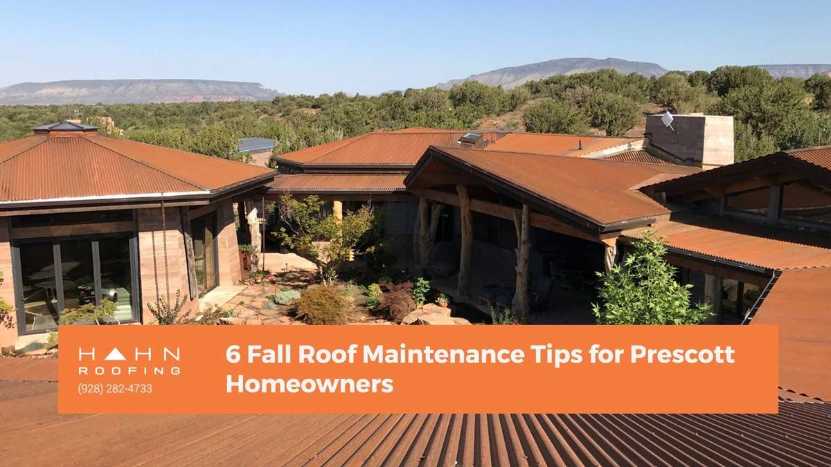 View of a house with a rusted metal roof, promoting 6 Fall Roof Maintenance Tips for Prescott Homeowners.