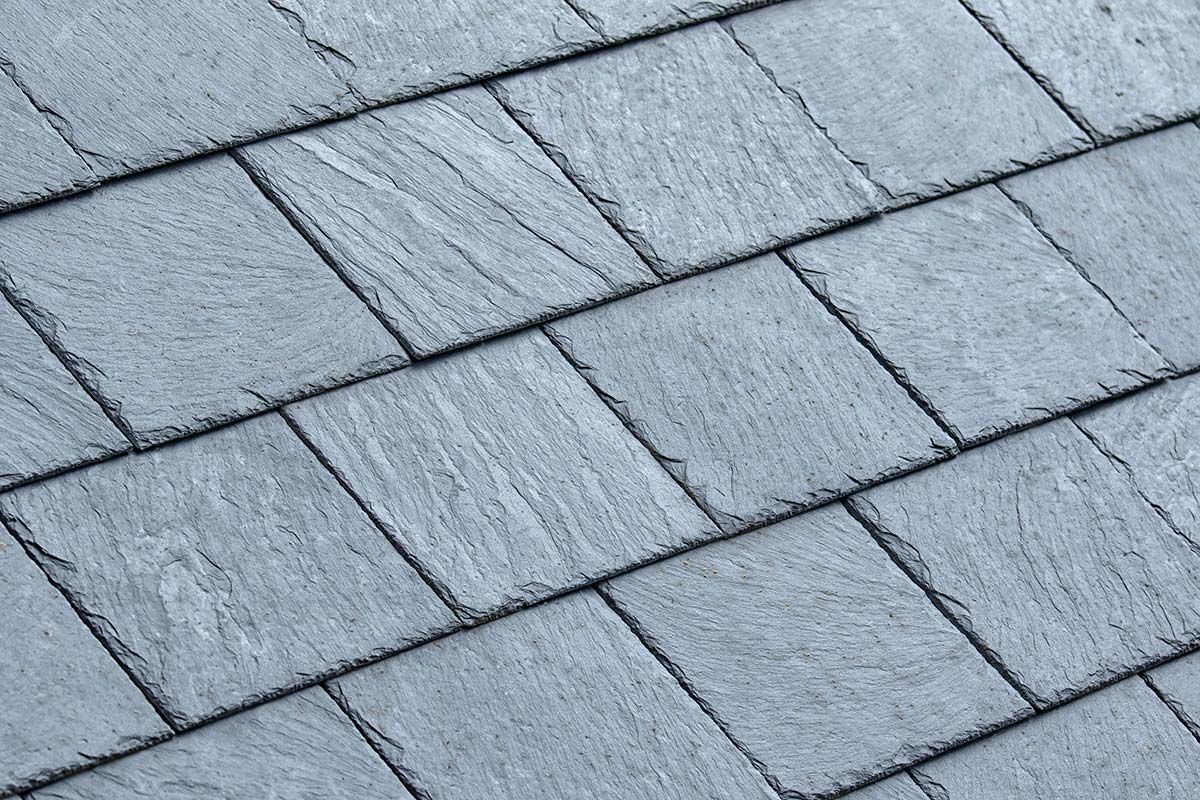 Close-up of gray slate roof tiles in a diagonal pattern.
