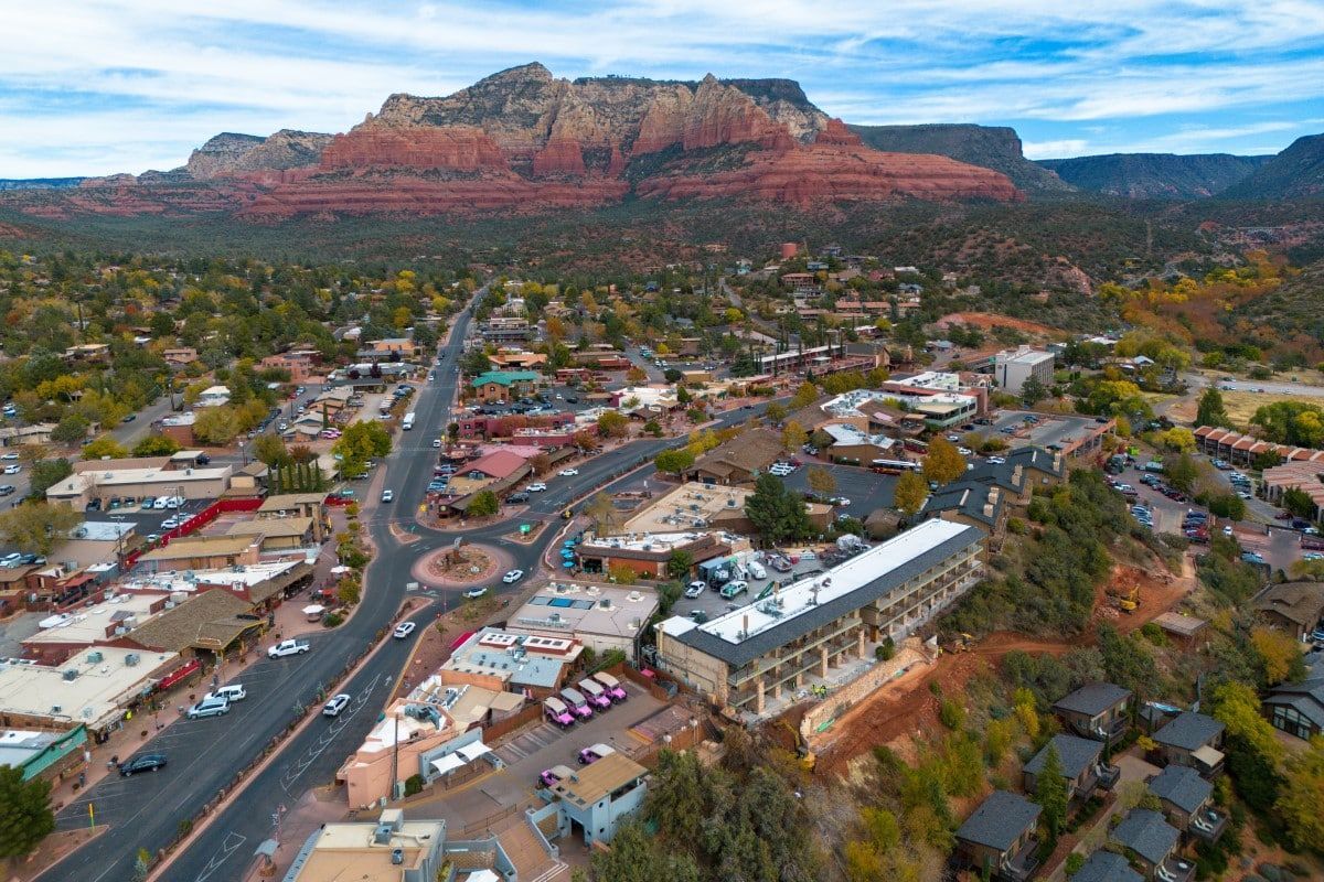 Aerial view of Sedona, Arizona, with red rock formations and a town with roads and buildings.