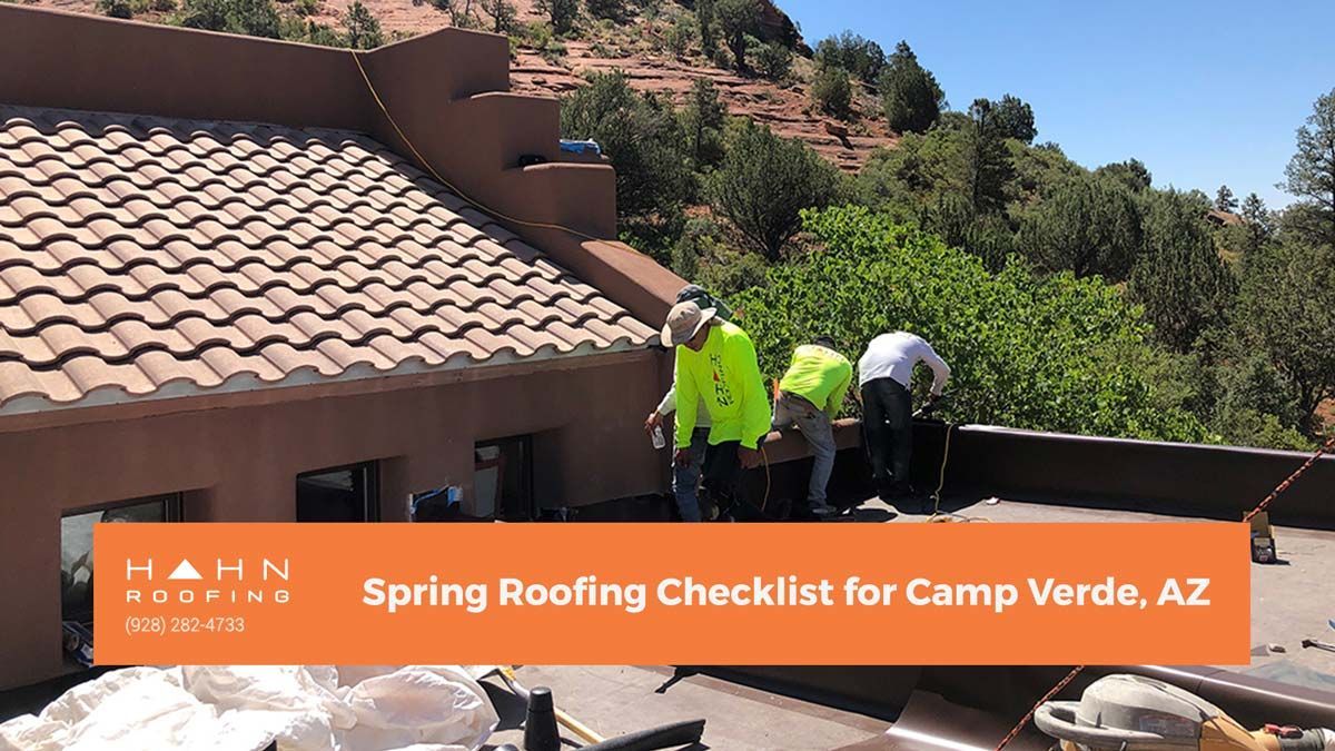 Workers in neon vests on a roof with clay tiles, Arizona landscape visible. 