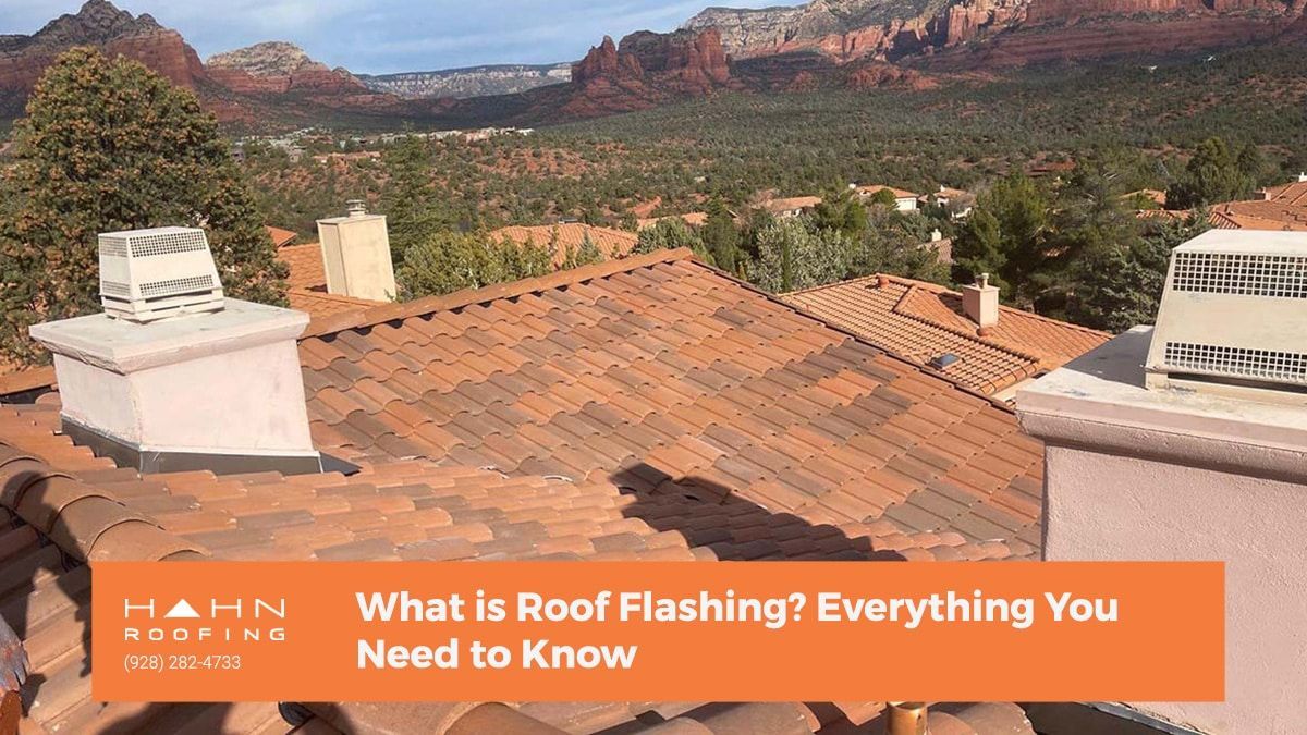 Red tile roof with chimneys against a mountain backdrop in Sedona, Arizona.