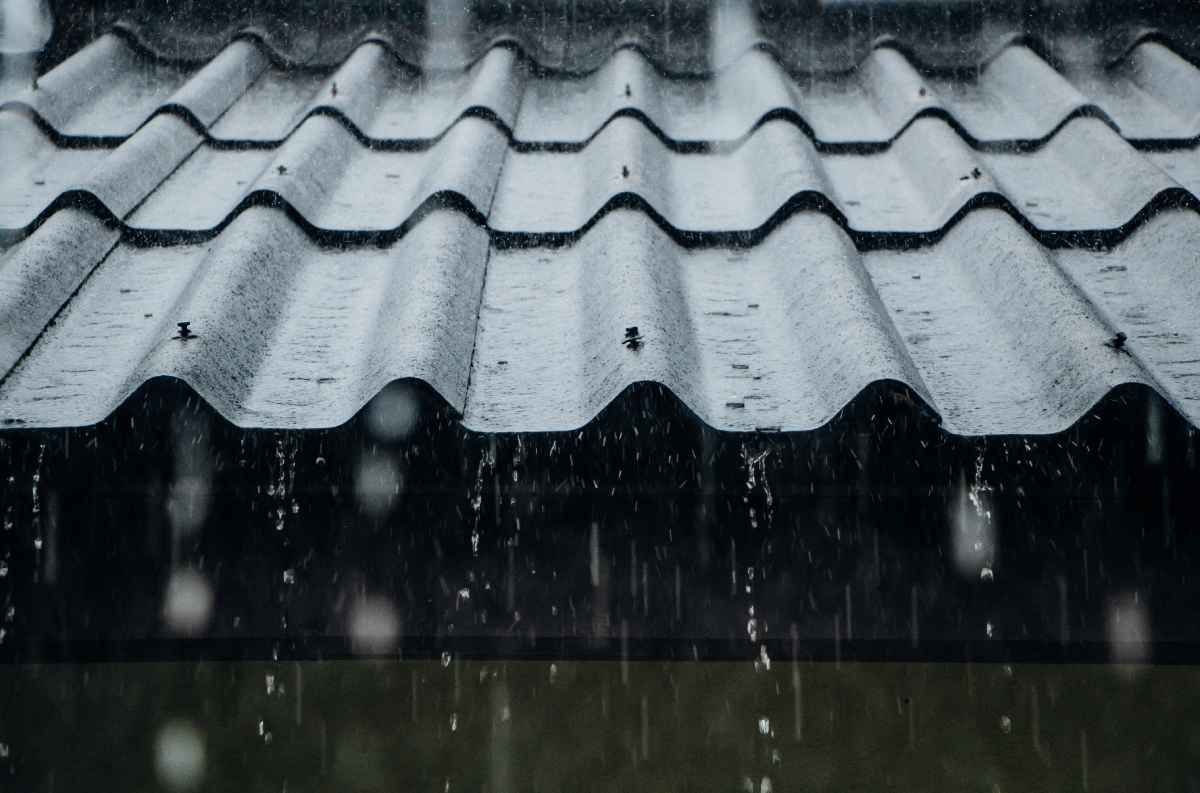 Rain falling on a corrugated gray roof.