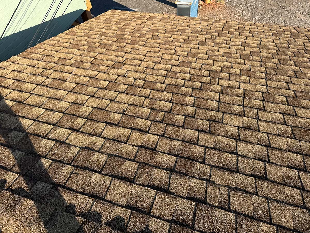 Overhead view of a brown asphalt shingle roof on a building.