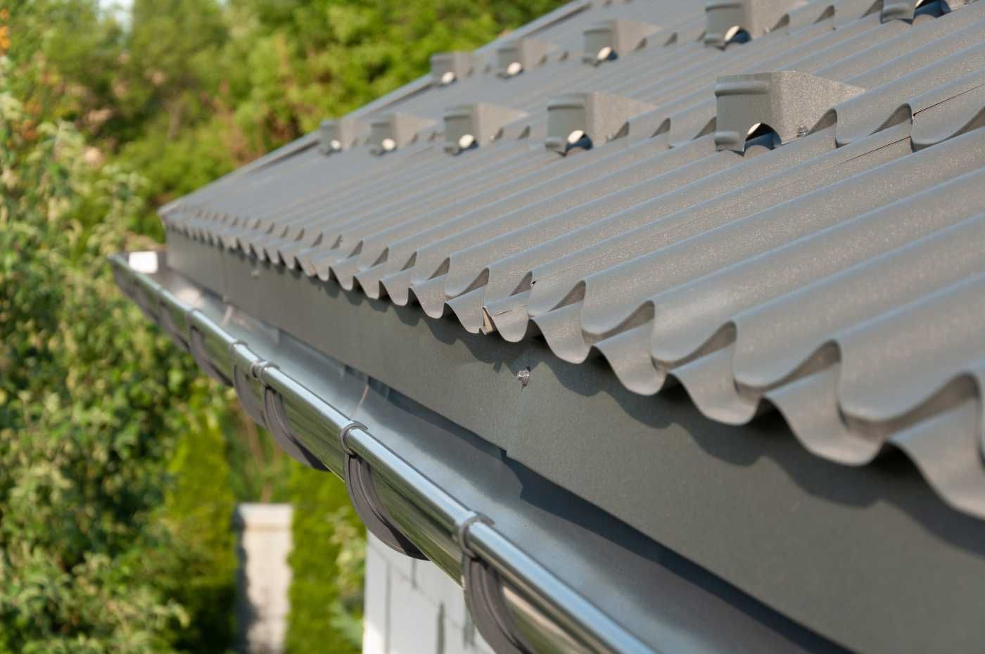 Gray metal roof with a gutter, close-up shot.
